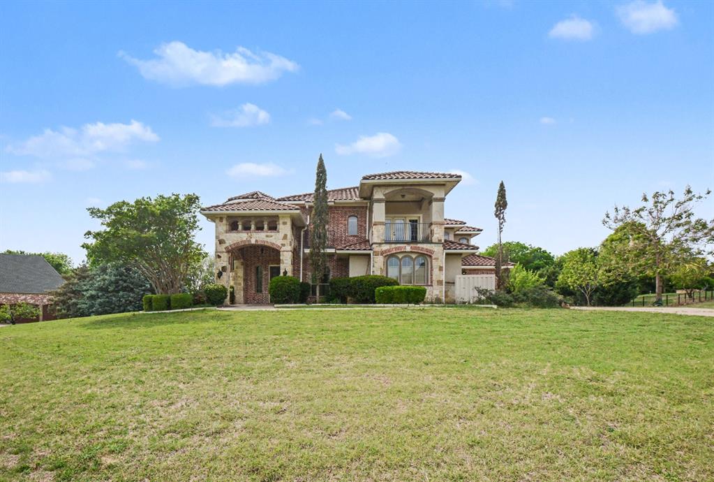 Stunning Mediterranean-inspired custom estate situated on a beautifully landscaped 1+ acre lot, backing to a serene tree line for ultimate privacy. This expansive residence offers approximately 4,600+ square feet of refined living space, featuring 4 bedrooms and 4 baths with exceptional architectural detail throughout. Designed for both everyday living and entertaining, the home showcases a gourmet chef’s kitchen complete with double ovens, gas cooktop, butler’s pantry, and an impressive wine grotto. Multiple living areas include a sunroom, media room pre-wired for surround sound, and elegant spaces highlighted by custom finishes, slate flooring, and decorator touches. Enjoy seamless indoor-outdoor living with three private balconies, a covered patio with fireplace, and a cedar pergola-covered deck. Residents benefit from proximity to top-rated schools within Allen Independent School District, known for strong academics and extracurricular programs, including the nationally recognized Allen High School. Enjoy easy access to shopping, dining, and entertainment at destinations like Watters Creek at Montgomery Farm and Allen Premium Outlets, as well as nearby parks, trails, and recreational amenities. The location offers a rare combination of tranquility, space, and convenience.