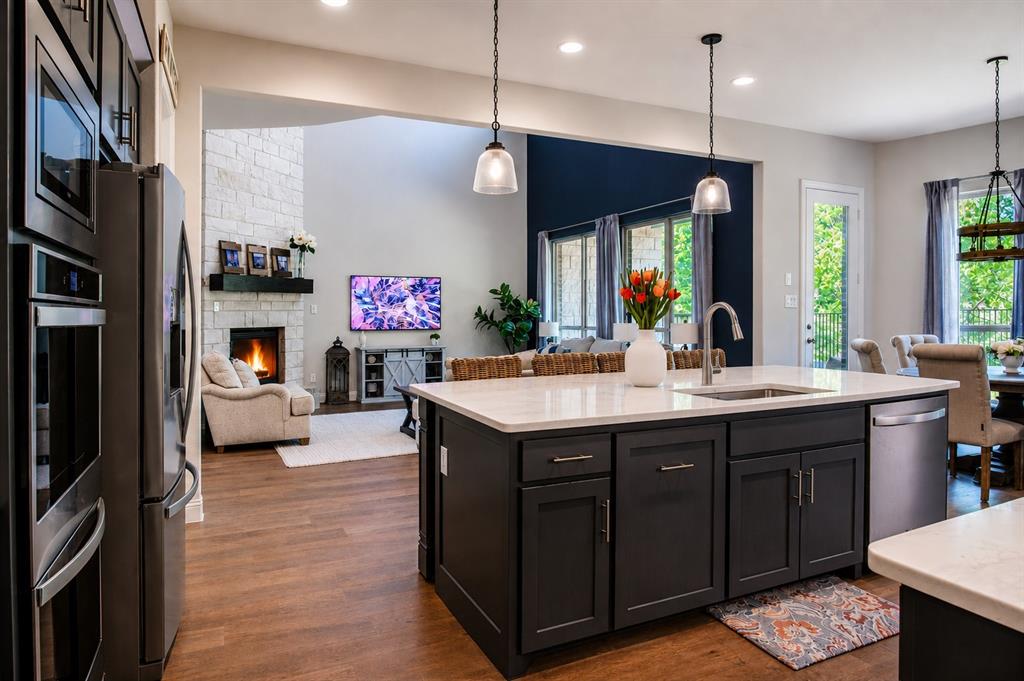 Before you sign a builder contract, compare this one! Designed to impress, this stunning home features a dramatic floor-to-ceiling stone fireplace that anchors the open-concept living and kitchen space. Built in 2022 and located in the highly desirable Breezy Hill community within Rockwall ISD, this 4-bedroom, 4-bath home offers nearly 3,800 square feet of thoughtfully designed space with a focus on openness, function, and elevated finishes with a bold sophisticated color palette that is just inspiring. Nature is your backyard with no rear neighbors plus a covered porch with fireplace.
The main living area flows seamlessly into the kitchen and dining spaces, offering multiple options for gathering including a breakfast nook, kitchen island with bar seating, and an additional space that could be a formal dining room or a cozy seating area. 
The kitchen is well-appointed with granite countertops, a large island, gas cooktop, double ovens, convection oven, and walk-in pantry.
The first-floor primary ensuite offers dual vanities, an oversized double shower, free standing deep soaking tub, and a spacious walk-in closet. A secondary bedroom and full bath on the main level provide flexibility for guests.
Upstairs includes a large lofted family room, dedicated media room, and French doors leading to a private office with access to a front-facing balcony, along with 2 generously sized secondary bedrooms featuring walk-in closets, including one with an ensuite bath.
Additional highlights include tankless water heater, vaulted ceilings, decorative lighting, utility room with built-in cabinets and space for a freezer.
 Well designed parking with three garage spaces total—two-car and separate single-car—plus expanded paved driveway parking..
Situated on a 0.20 acre lot, this home offers a rare combination of privacy, space, and modern construction in an active, well-maintained community. Community pool, trails, pond with dock, playground, and a covered pavilion.
