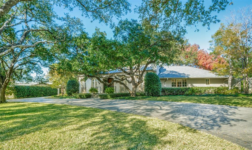 Stunning Traditional 5 bedroom, 5.1 bath prestigious Preston Hollow home with French flair sits on half acre of lush landscaping under a canopy of mature trees. Secured off the circular drive by a scrollwork iron gate, this exquisite property features a stucco and stone exterior with gas lanterns.  Upon entering the expansive foyer you're greeted on the left by the formal dining, on the right by the study or library and straight ahead the great room with views of the magnificent columned wrap around back porch. Two fireplaces make for cozy entertaining.
The large Master and 3 additional bedrooms are downstairs with a large 5th bedroom or game room and ensuite bath upstairs with multiple staircases.
The Chefs kitchen features soapstone countertops, stainless appliances, warming oven, Sub-Zero refrigerator and opens to a large den.
This property is ideal for hosting grand events or intimate gatherings in a serene private setting.