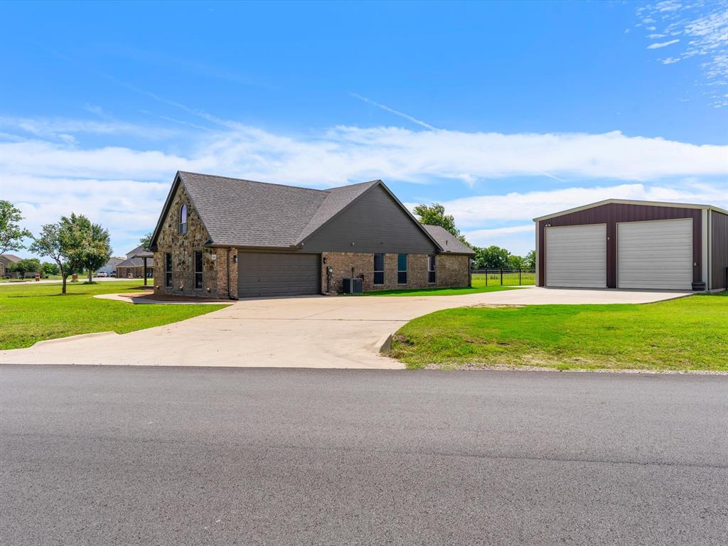 Welcome to this beautifully updated single-story home nestled on a quiet cul-de-sac lot in Unincorporated Northwest ISD! Single Level Living boasting 4 bedrooms, 3 updated bathrooms, and an exceptional detached workshop with independent electricity, this property offers the perfect blend of comfort, style, and versatility. The charming brick and stone exterior is complemented by a wrap-around covered front porch, creating an inviting first impression. Inside, real hardwood flooring flows throughout the common areas and primary. Cozy central living space anchored by a painted white stone wood-burning fireplace with propane starter option. The stunning remodeled kitchen is truly the heart of the home, featuring a beautiful combination of white oak and white shaker-style cabinetry, a massive waterfall quartz island, stainless steel KitchenAid appliances including fridge, electric cooktop, pantry, designer pendant lighting, and a breakfast area perfect for everyday dining. All bathrooms have been tastefully updated - Two with walk-in showers and elegant vanities offering abundant storage and one with Tub-Shower combo. The spacious primary suite showcases white oak wood flooring and a relaxing ensuite bath complete with dual sinks, a soaking tub, and more storage. Step outside to enjoy the extended covered back porch overlooking a spacious, fully fenced backyard with plenty of room to play, garden, or entertain. Hobbyists, craftsmen, and DIY enthusiasts will appreciate the oversized workshop with electricity—an incredible bonus rarely found at this price point.  Recent epoxy coated garage floors for your enjoyment. Conveniently located and zoned for Northwest ISD, including Eaton High School, this move-in-ready property offers modern updates, flexible living spaces, and room to pursue your passions both inside and out.