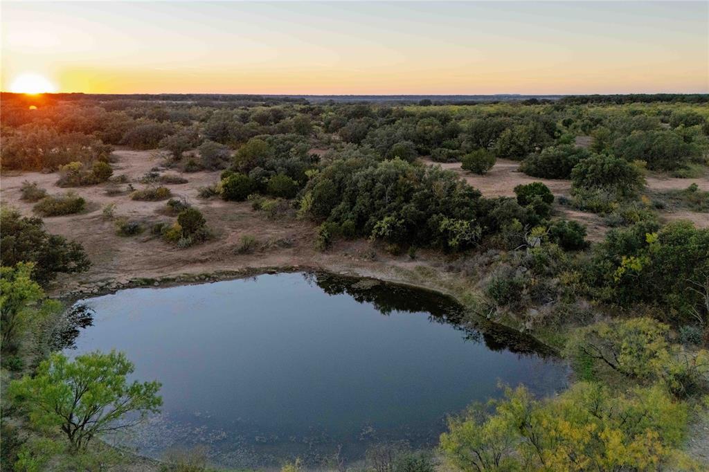 Centennial Ridge Ranch is 154.5± acres located just 8 miles southwest of Brownwood, Texas, offering convenient access to town and essential utilities already in place. The property features frontage on FM 1176 and County Road 201, providing multiple access points.

The land includes water, electricity, and an on-site septic system. Improvements consist of a 20x30 metal implement barn, a 440-square-foot hunting cabin, and a 10x20 storage shed. The terrain varies by approximately 90 feet, creating a mix of open pasture, wooded cover, and elevated viewpoints providing scenic views.

Three ponds stocked with channel catfish and perch enhance the property’s versatility for both recreation and wildlife management. The habitat supports whitetail deer, turkey, dove, and quail, with native vegetation such as post oak, live oak, red oak, mesquite, and bee brush providing excellent cover.

A 40-acre pasture of Kline grass mixed with mesquite extends to the FM road, while the highest point of the property is a scrub oak-covered hill that serves as a bedding area for deer.

This property combines rural privacy with convenient proximity to Brownwood’s amenities, making it suitable for hunting, recreation, or country living.