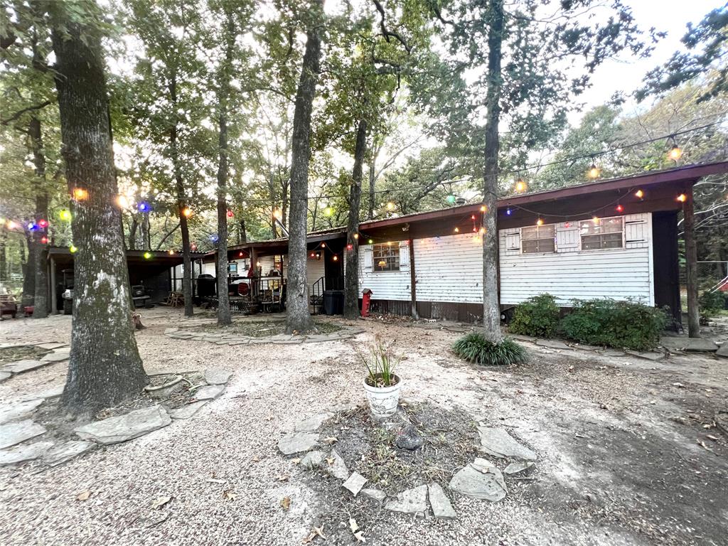 APPRAISED at 149,000 GIVING YOU INSTANT EQUITY! Welcome to your dream retreat! Nestled in a serene lake-view setting, this charming home offers a perfect blend of comfort and potential. Imagine waking up to stunning lake views and enjoying your morning coffee on the front porch. Or take it to your back porch, which adds approximately 420 sq ft of bonus space for relaxation or entertaining. The beautifully landscaped lot is dotted with mature trees, providing both privacy and a picturesque backdrop for your outdoor activities. With two gated entrances, accessing your property is convenient and secure. You'll also appreciate the workshop equipped with electricity, ideal for hobbies or additional storage. Whether you're looking to move in and make it your own or envision building your dream lake house from the ground up, this property presents endless possibilities. The home is being sold as-is, allowing you the freedom to explore your creative vision. Don't miss this opportunity to have your perfect lake-view oasis!