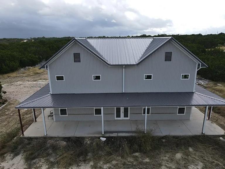 Discover your dream home in the serene, gated Greystone Ranch community, nestled in the heart of Texas Hill Country. This 10.59-acre estate at 1901 Greystone Ranch Rd, Bertram, TX, offers a perfect blend of rustic charm and modern convenience, ideal for those seeking tranquility without sacrificing accessibility. Located just 15 minutes from Burnet, 45 minutes from Austin, and minutes from the Highland Lakes, this property provides a peaceful retreat with easy access to urban amenities, dining, wineries, and recreational activities like fishing, camping, and golfing.

The home features a versatile open-concept layout with vaulted ceilings and exposed beams, creating a warm and inviting atmosphere. The flexible floor plan is a blank canvas, ready to be customized into a cozy family home, a luxurious retreat, or an entertainer’s paradise. The low-maintenance metal siding exterior and expansive wraparound porch invite you to unwind while enjoying breathtaking Hill Country views, framed by mature oaks and gently rolling terrain.

A standout feature is the 1,500 sq. ft. insulated shop, complete with 8-inch spray foam insulation, a full bathroom, and underground electric connections to both the house and shop. The property is equipped with a 500-gallon propane tank Generac generator, ensuring uninterrupted power for both structures. The predominantly level lot, with a gentle slope, supports a wildlife exemption (transitioning from a Black Buck grazing lease in 2021), allowing for low taxes.

Additional highlights include:
Paved roads and electricity throughout the gated Greystone Ranch community
Abundant wildlife, including deer and turkey, perfect for nature enthusiasts
Proximity to top-rated schools in the Burnet Consolidated Independent School District
Secluded yet convenient location, close to Austin and Highland Lakes attractions
Whether you envision a weekend getaway, a forever home, or a recreational ranch, this property offers endless possibilities.