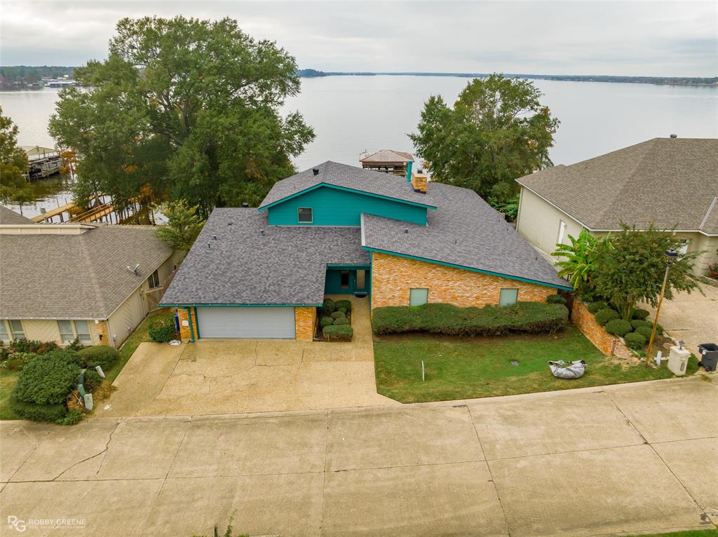 There is just not enough space here to describe this awesome lake home!  Views of lake from the entire rear of the home, open floor plan from kitchen, dining and living area.  Huge party room with roll up door that opens to patio and pool area.  All bedrooms have their own bathroom and are super spacious.  There are 2 office spaces in the house, one downstairs and one upstairs near the primary bedroom.  Out back there is a covered patio, infinity edge pool, hot tub, woodburning fireplace with a brick pizza oven on the side.  There is a long pier with a 2 stall boathouse with lifts.  It olso has a place to clean fish out on the dock.  This house is consumed with storage and great living spaces!!  It is the perfect place to spend your time outdoors. 85 ft lake frontage- Pier, boat house and lifts are all sold as is. Pre approval required prior to showing property.