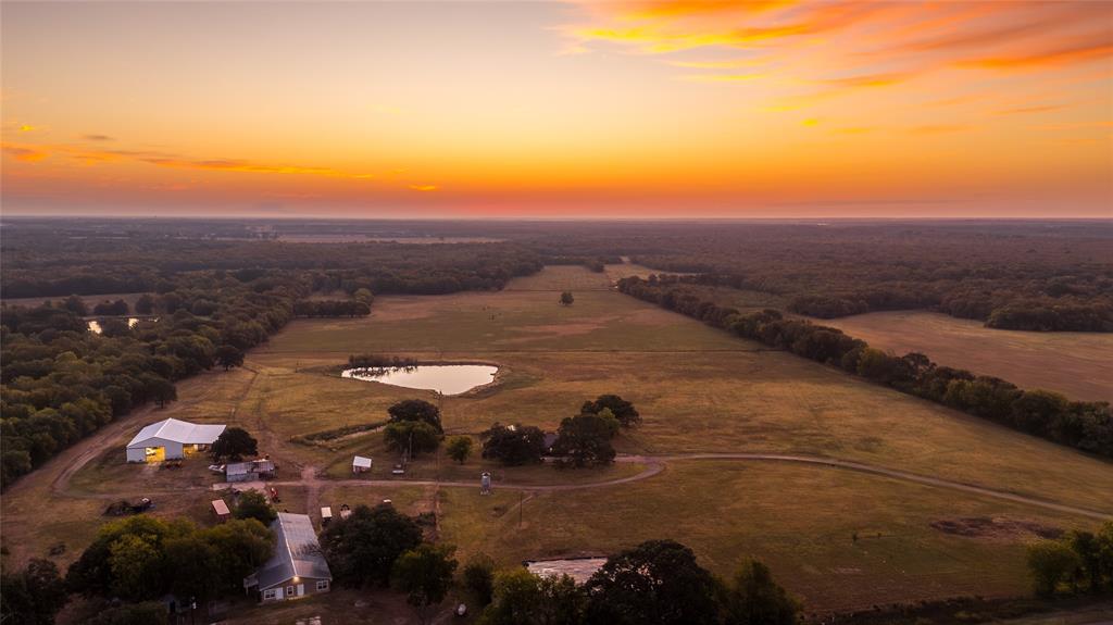 197.6 Acres Delta County, TX
Located just 5.7 miles east of Cooper, the Spotted Dawg Ranch offers 197.6 acres of exceptional land combining productive pastures, mature hardwoods, and diverse wildlife habitat. The property features four stocked ponds, multiple seasonal creeks and draws, and rolling terrain ideal for both ranching and recreation. Pastures consist of common Bermuda, Dallas grass, Big and Quick crabgrass, Johnson grass, Alamo switchgrass, and ryegrass, providing excellent grazing and hay production.
The main ranch house includes 5 bedrooms and 4 baths with an open-concept kitchen, dining, and living area. The large kitchen offers an oversized island, dual oven range setup, and abundant natural light, while the living room’s wood burning stove provides efficient warmth throughout the home.
Additional improvements include a 123×40 old dairy barn with covered cattle working facilities and a 1 bed, 1 bath apartment with full kitchen, perfect for guests or ranch help. A 50×80 pole barn with 30×80 lean to offers ample hay and equipment storage. Other structures include a 20×24 chicken coop, 40×16 garden shed, and 40×18 livestock loafing shed. The property also features a large organic garden, fruit orchard, and is fenced and cross-fenced for rotational grazing.
Wildlife is abundant with whitetail deer, hogs, turkey, and seasonal waterfowl. The ranch offers easy access and significant road frontage along Highway 19, with proximity to Paris, Sulphur Springs, and the greater North Texas region. A rare opportunity to own a versatile, well improved property suited for livestock, hay production, hunting, or a self-sufficient country lifestyle.