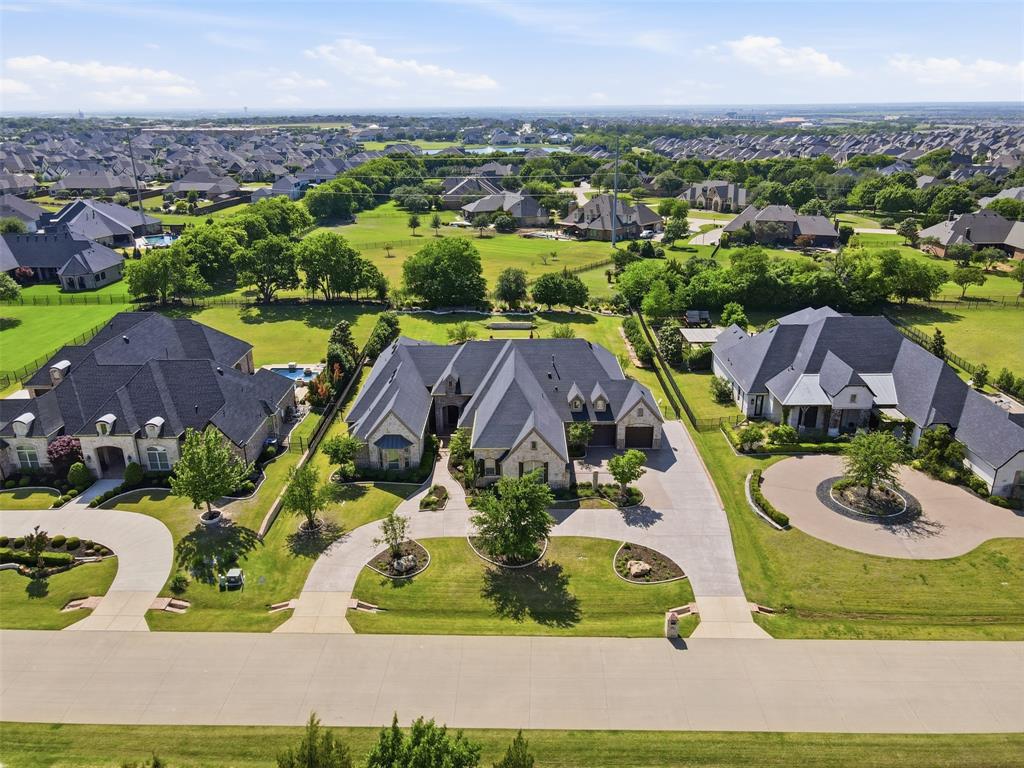 Stunning custom one-story ranch-style estate situated on a sprawling .74-acre lot in the highly sought-after Whispering Meadows community. Exceptional curb appeal welcomes you with a private courtyard featuring a covered sitting area and cozy fireplace—perfect for entertaining or relaxing.

Inside, you’ll find a beautifully designed open-concept floor plan with high-end finishes throughout, including a wine room with refrigerators, sink, and custom built-ins. The gourmet kitchen is a chef’s dream, equipped with Wolf stainless steel appliances, built-in Sub-Zero refrigerator, oversized island with seating, designer backsplash, and an expansive walk-in pantry.

The kitchen flows seamlessly into the breakfast area and spacious living room, highlighted by vaulted cedar beam ceilings, a fireplace, and walls of windows providing natural light and backyard views.

Private study with built-ins and its own fireplace. The luxurious primary suite features a sitting area and bonus room ideal for a gym, nursery, or office. Spa-inspired bath includes soaking tub, oversized shower, dual vanities, and custom walk-in closets.

Media room and game room with courtyard access. Secondary bedrooms are generously sized with ensuite baths for privacy.

Resort-style backyard with heated pool, firepit, covered patio, built-in grill, outdoor refrigerator, putting green, and ample green space.

Additional features include a utility room with mudroom and washing station, oversized 4-car garage with storage and workspace, and oversized attic (“Texas basement”).