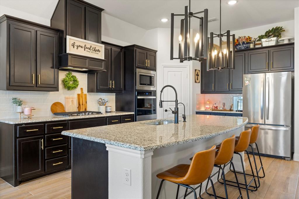 Assumable FHA Loan of 420,000 at 4.99! Sellers are motivated.

Completed in 2024, this 4-bedroom, 2-bath home delivers a refined take on modern living with intentional design and upgraded features throughout. The striking stone veneer exterior sets the tone, while inside designer touches and thoughtful selections bring fill the home with warmth and character.

Step inside to an inviting living space centered around a beautiful floor to ceiling stone fireplace. The kitchen makes a statement with granite countertops, black cabinetry, and gold hardware, blending bold design with timeless appeal. A separate dining room provides a dedicated space for hosting or a flexible space as a second living area.

The primary suite is spacious and designed as a true retreat, offering a private sitting area, dual vanities, abundant natural light from large windows, a separate tub and shower, and an oversized walk-in closet. In addition, the home offers three secondary bedrooms, one of which is well-suited for use as a home office.

Throughout the home ceramic wood-look tile adds durability and style, and 10' ceilings keep everything feeling open.

Enjoy added value with a whole-home Puragain water filtration system and reverse osmosis drinking water in the kitchen. These features bring long-term comfort and convenience. 

Designer window coverings, ceiling fans, and gutters are already in place, making this home truly move-in ready.

Stylish, functional, and thoughtfully upgraded—this home stands out in all the right ways.