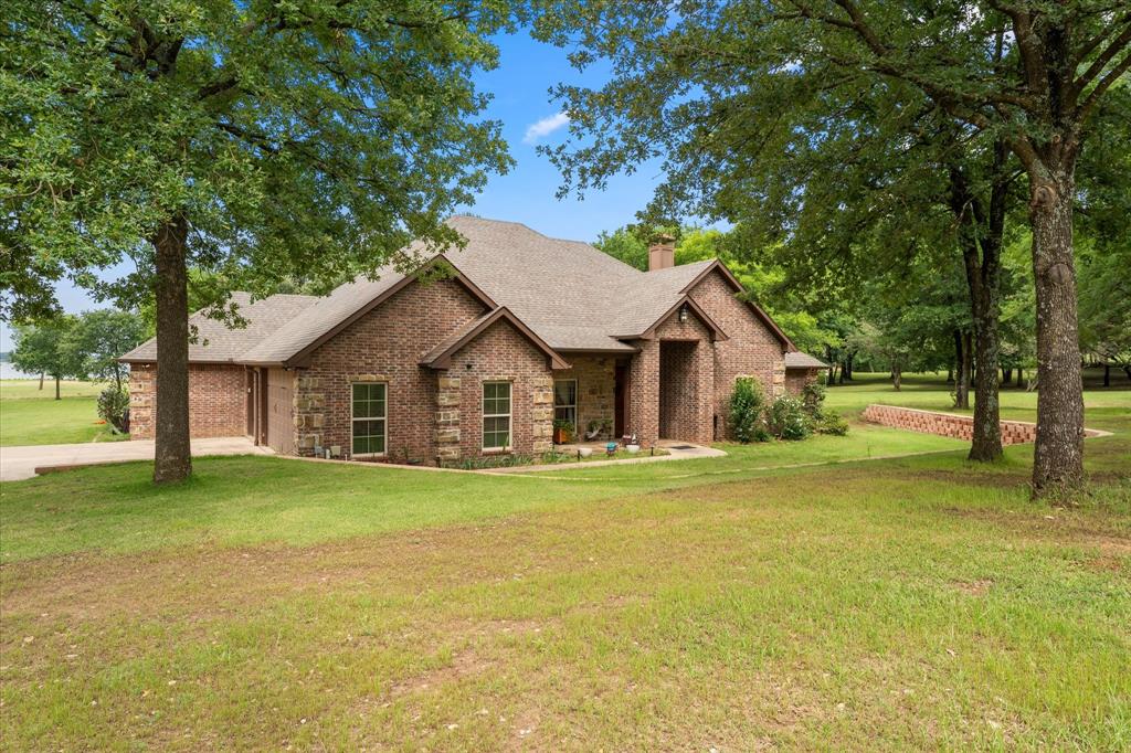 Tucked away at the end of a quiet cul-de-sac in the prestigious Star Ranch section of Lake Fork Ranches, this private brick estate offers some of the most breathtaking sunset views on world-famous Lake Fork. A long winding driveway leads to the 3-bedroom, 3-bath home with a 3-car garage, perfectly positioned to capture expansive water views and the peaceful beauty of East Texas lake living. Inside, you’ll find a beautiful kitchen with hardwood cabinetry, granite countertops, engineered hardwood and tile flooring throughout, formal dining, and a spacious breakfast nook. The wonderfully private library-study features built-in desk space. Two fireplaces provide warmth and ambiance—one indoors and one on the covered patio beside the outdoor kitchen. The detached metal building includes an excellent shop plus a 2-bedroom, 1-bath guest house, ideal for visitors or extended stays. A large fenced-in yard offers plenty of room for pets and animals. Lake Fork is nationally recognized as one of the premier trophy bass fishing lakes in America, offering over 27,000 acres of water and more than 300 miles of shoreline for fishing, boating, and recreation.