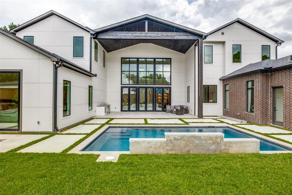 A striking contemporary masterpiece by Chellyanna Custom Homes, thoughtfully designed for modern luxury living in the heart of North Dallas. Spanning 7,270 square feet, this exceptional residence offers 6 bedrooms and 7.1 baths with an open-concept floor plan that seamlessly blends everyday living with elegant entertaining.

Upon entry, dramatic ceilings exceeding 20 feet in the main living area create an unforgettable architectural statement, while a hidden staircase adds a distinctive custom design element. Expansive windows flood the home with natural light, and white oak flooring extends throughout, enhancing the home's clean, sophisticated aesthetic.

The first floor features a private study, a spacious guest suite, and a luxurious primary retreat with a spa-inspired bath. The gourmet kitchen is appointed with Thermador appliances, including double ovens, an oversized island, custom cabinetry, a butler's pantry, and a breakfast nook. Open to the expansive living room, the kitchen overlooks the covered patio, resort-style pool, outdoor kitchen, and backyard, creating a seamless indoor-outdoor living experience.

A formal dining room, built-in wine display and storage, and a stylish wet bar provide the perfect setting for hosting family and friends.

Upstairs offers four spacious en-suite bedrooms and a versatile bonus room ideal as a media room, fitness studio, playroom, or additional living space.

Additional features include a three-car garage and exceptional craftsmanship throughout. Ideally located near Dallas' premier private schools, fine dining, upscale shopping, and major thoroughfares, this extraordinary residence offers the perfect blend of luxury, functionality, and timeless contemporary design.