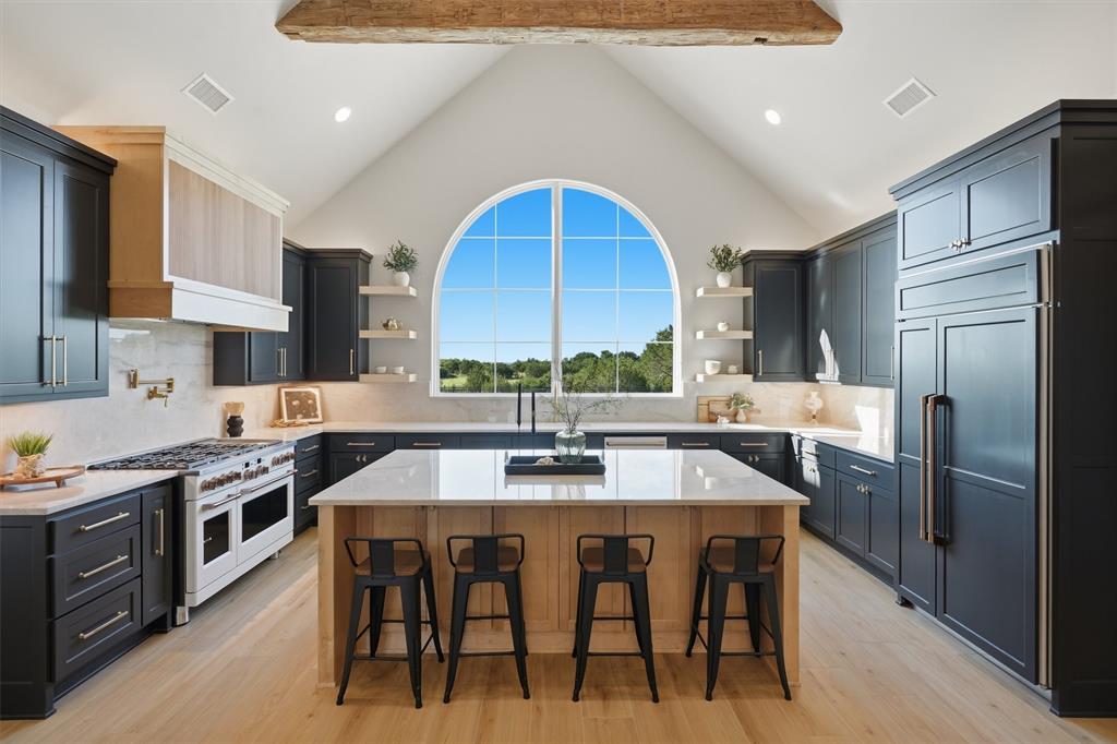 This stunning 4,253 square foot custom home on 2 acres was designed to make a statement. The home offers 4 bedrooms, 4 bathrooms, a private office, and a flexible second suite with direct access to the pool and patio area. Upstairs, a large bonus room creates the perfect space for a movie room, game room, or private workout area.
Inside, the home was thoughtfully designed with custom features including quartzite countertops, GE Café appliances including a 48 inch commercial style range, reclaimed old beams, a custom fireplace mantle, and a grand arched kitchen window that captures the incredible views behind the home. The open layout, large living spaces, and abundant storage make the home feel both luxurious and comfortable.
The backyard was built for entertaining with a pool and spa, outdoor kitchen, fenced yard, and peaceful ranch views stretching behind the property. Additional features include a 3-car garage, Sonos home sound system, security cameras, backup generator, 1,000-gallon propane tank and water softener and filtration system. Every part of this home was carefully designed to combine luxury, function, and timeless style.