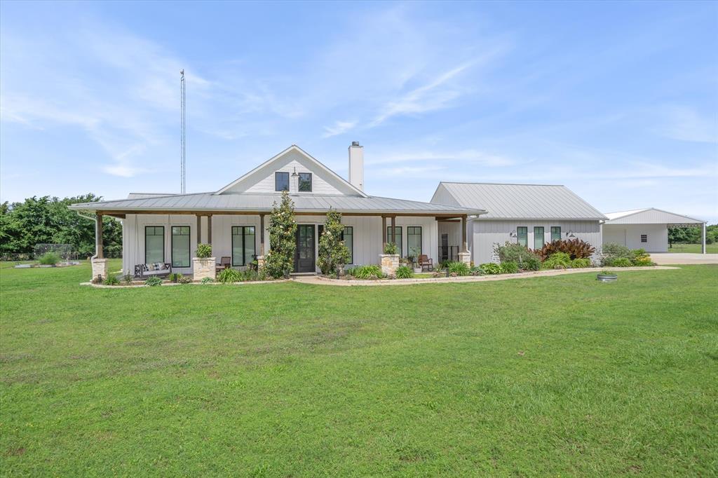 Custom-built in 2020, this stunning 4-bedroom, 2-bath home perfectly blends luxury, comfort, and country living on 5.48 acres. Thoughtfully designed with an open concept layout and split bedroom floor plan, the home is ideal for both everyday living and entertaining. The living, dining, and kitchen areas flow seamlessly together, making hosting effortless for everything from holidays to summer pool parties. You will love gathering around the oversized island, relaxing by the pool, or enjoying evenings on the expansive front porch overlooking the pond. The Butler’s pantry adds both charm and convenience, while custom touches throughout the home make every space feel elevated and inviting. The primary suite serves as a peaceful retreat, featuring a spa like ensuite with a walk-in closet. Got tiny guests? They will love the custom built-in bunk beds! Work from home? One room is tucked away creating the perfect work from home setup. Outside, the property continues to impress with turf, a pond, raised garden beds, a greenhouse, and fruit trees for those dreaming of a more self-sufficient lifestyle. Not one, but two shops that are both are spray foamed and heated and cooled. One has a bathroom and offers endless possibilities, whether you envision a home business, gym, or the ultimate mancave or a MIL suite. Either way, two shops offer the ideal combination of workspace and convenience. Combined with the whole-home generator this one-of-a-kind property was thoughtfully designed to offer peaceful country living without sacrificing modern amenities.