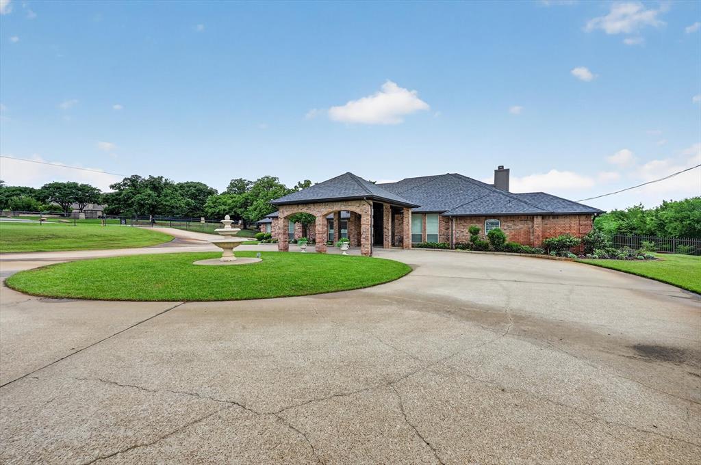 Welcome to a one-of-a-kind executive estate, gracefully sited on three acres, free from city taxes. As you approach, the gated circular drive hints at the grandeur within, while the porte cochere offers a dramatic and convenient entrance for guests and residents alike.Step inside to discover a spacious, light-filled foyer that opens into formal living and dining spaces, ideal for hosting elegant gatherings or intimate family dinners. Oversized windows throughout the living area frame picturesque views of the backyard, bathing the rooms in natural light and creating a seamless connection to the outdoors. A cozy wood-burning fireplace anchors the living room, providing warmth and ambiance on cool evenings.The gourmet kitchen is a chefs delight, boasting rustic, Tuscan-inspired brick accents that surround the cooking area. The kitchen features a generous island, marble countertops, stainless steel appliances,breakfast bar for casual dining, & sunlit eating nook.Primary suite is a true sanctuary,featuring double-sided fireplace that flickers between the bedroom & spa-inspired ensuite bath. Unwind in the deep soaking tub or refresh in the oversized glass-enclosed shower. Dual vanities & ample storage complete this luxurious retreat.Three additional bedrooms ensure space for family and guests, while Jack-and-Jill bath provides accessibility & privacy. The expansive family room is designed for memorable moments, omplete with a built-in wet bar, abundant windows, & direct access to the outdoor living spaces. Step out to the sparkling play pool and shaded patio—perfect for summer parties or relaxing afternoons.Equestrians & hobbyists will appreciate the separate barn, thoughtfully equipped with seven roll-up bay doors for access and two stalls for horses. The attached carport offers ample room for boats, recreational vehicles, or equipment. The estate is cross-fenced with durable pipe fencing. Experience refined country living at its best—this showpiece estate is a must-see!