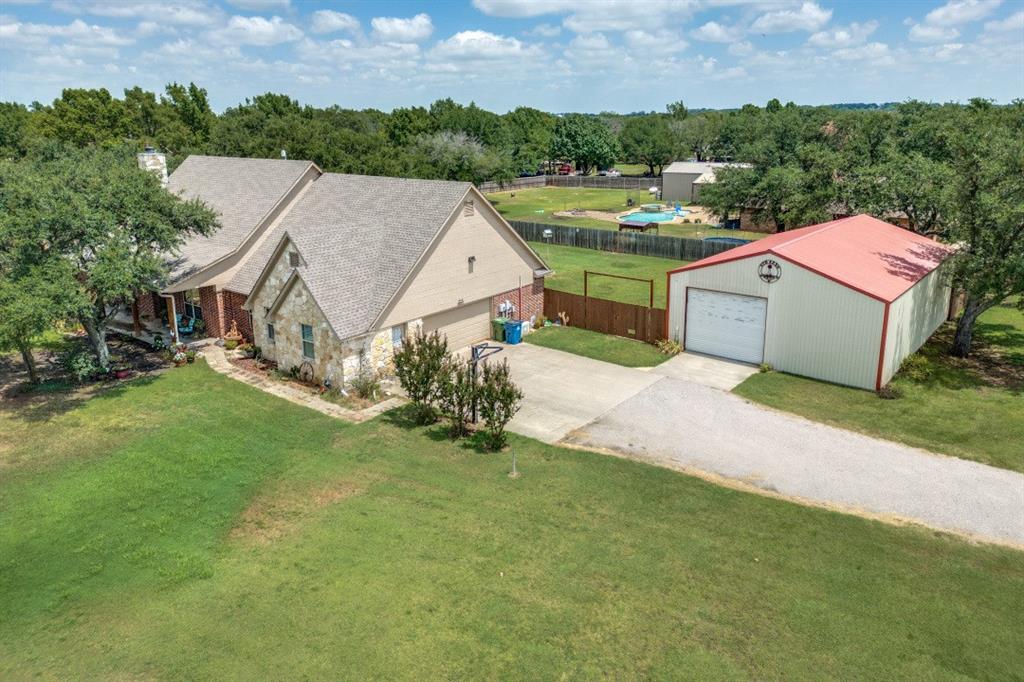 Lovely Custom 4-bedroom home situated on a beautiful 1-acre lot in Live Oak Estates, just outside the Collinsville city limits! This move-in ready property offers spacious living, thoughtful updates, and NO HOA — plus no city taxes! The inviting living area features vaulted ceilings, plantation shutters, floor-to-ceiling stone fireplace, & a fantastic wood pellet stove insert with thermostatic control. Wide plank wood-look tile flooring flows throughout most of the home, while two secondary bedrooms feature plush carpeting.The kitchen has a large island, custom cabinetry, tons of storage, a cute coffee bar area, & an oversized walk-in pantry with room for a freezer or second fridge. High-end VIKING appliances include a double convection oven, 6-burner gas cooktop, vent hood, and warming drawer. Recent updates include: *2024 HVAC with Ecobee Smart Thermostat*2025 High-Impact Composition Roof * 2025 Exterior Paint * 2025 Hardy Board Eaves Replacement * 2026 Water Heater * 2026 Interior Paint. The spacious primary suite offers vaulted ceilings, plantation shutters, and large windows overlooking the property. The ensuite bath features separate vanities, separate tub & shower, + a walk-in closet. Secondary bedrooms are generously sized with excellent closet space and ceiling fans throughout. The versatile den can serve as a game room, kids’ TV room, home office, or workout room. Outside, you’ll love the covered front & back porches, mature live oak trees, and separate fenced dog run or chicken area. The cedar fencing is built to last with sturdy steel posts and railings. The impressive 30x45 insulated workshop *man cave* includes electric and water, two overhead roll-up doors *one automatic, one manual*, plus floored attic storage. Additional floored attic storage is also available in the home. Chickens are allowed, & this wonderful neighborhood offers peaceful country living with convenience nearby.