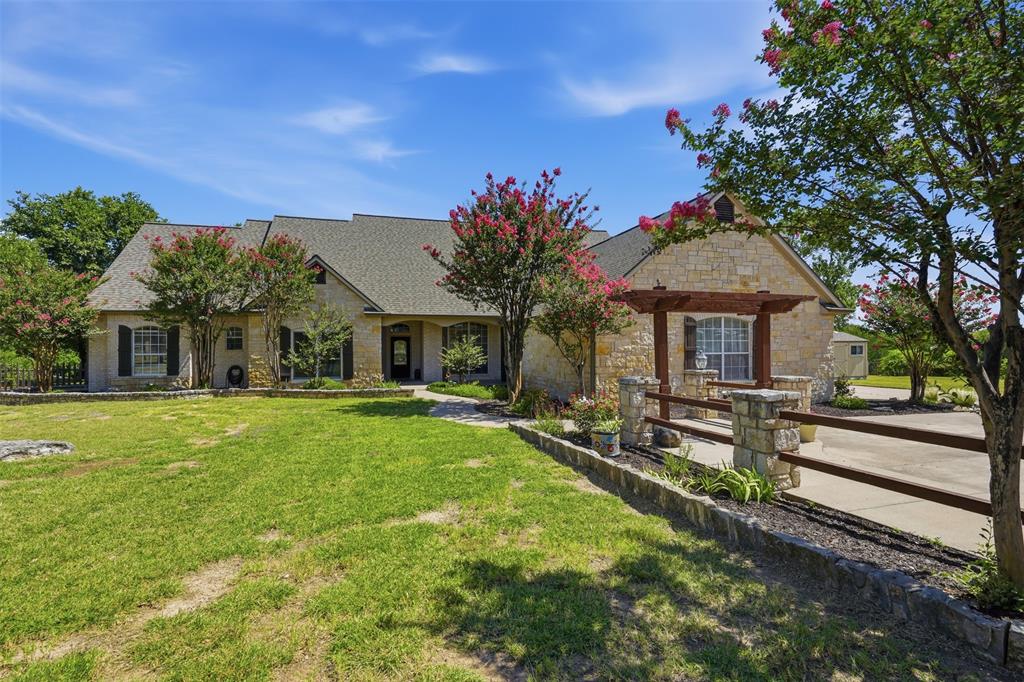 Welcome to a blend of Texas charm and everyday livability, located in the highly sought-after Aledo ISD. Set on a full one-acre homesite, this beautifully designed 4-bedroom, 4-bath residence offers over 3,400 square feet of thoughtfully curated living space with exceptional flexibility and timeless appeal. A striking stone exterior and inviting covered front porch create an immediate sense of arrival, setting the tone for the warmth and character found throughout. Inside, the main living area is anchored by a dramatic stone fireplace, complemented by a wood-beamed inset tray ceiling that adds architectural depth and custom sophistication. Ceiling fans throughout all bedrooms enhance comfort and efficiency, blending practicality with comfort. The main level offers an open yet defined layout, designed for effortless flow between living, dining, and kitchen spaces—ideal for both intimate daily living and larger gatherings. Natural light enhances every corner of the home, highlighting its inviting and spacious design. The private primary suite provides a peaceful retreat with a well-appointed en-suite bath and generous closet space, while secondary bedrooms offer versatility for guests, family, or workspace needs. Upstairs is an exceptional highlight—fully reimagined as a flexible second living environment. A beautiful wood staircase leads to a spacious upper-level retreat featuring a large game room, private office, additional bedroom options, and a full bathroom. Designed with multi-generational living in mind, this level functions beautifully as a guest suite, teen retreat, creative studio, or private work-from-home sanctuary. Its scale and versatility elevate the home beyond the expected. The one-acre setting offers room to breathe, expand, and enjoy outdoor living with privacy and potential for future enhancements. A three-car garage and ample parking. This is more than a home it’s a lifestyle opportunity defined by space, flexibility in West Fort Worth.