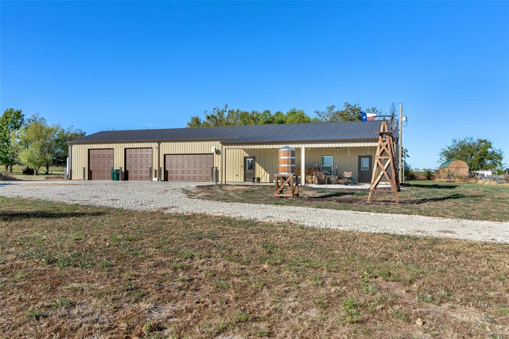 Owner will carry note to qualified buyer. Approx. 3,000 square feet cooled and heated barndominium with approximately 1050 sq ft living area. Living space includes master bedroom with walk in closet, electric fireplace, walk-in shower and stacked washer&dryer unit in master bath. Open concept living and kitchen area with wood slat ceilings. Kitchen island with seating and live edge bar top. Walk out of the kitchen onto the large, covered patio where the family gatherings make wonderful memories. Second bedroom has bathroom with walk in shower off workshop. Covered back patio off the workshop-garage area also. Shop and home on separate electric breakers and RV outlet in place on back of home. Home has HVAC and workshop-garage has a mini split unit. Garage has 3 automatic doors with lots of room for an office area and workshop area. Dirt work has been completed for a house pad as well. Conex storage building with electricity connected. Concrete parking in front of the garage-workshop. Additional acreage available as shown in aerial picture.