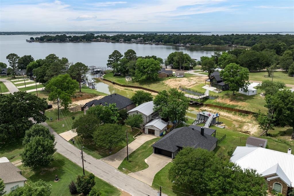 Lake Front Home on Cedar Creek Lake. Great size for all the family! There is an enclosed garage for a guest house, or Mother-in-Law Suite with kitchenette and bathroom. Located close to Main Street shopping and restaurants. The area allows short term rentals if registered with the city office. The home has a quirky Lake House vibe. New HVAC system in 2022. Newer retaining wall and pier. Perfect outdoor set up for family gatherings. The kitchen has a massive pantry area. Enclosed sun porch with window unit. Gun Barrel City is approximately 45 minutes East of Dallas. Cedar Creek Lake makes the perfect get a way for Dallas residents and is growing rapidly with more restaurants and great entertainment. Come make memories that will last a lifetime!