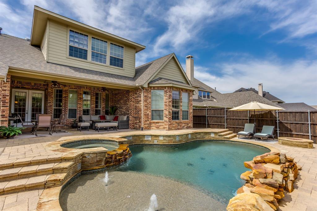 Priced to sell and set within a neighborhood that offers a community pool and park, this home blends spacious gathering areas with thoughtfully designed private spaces. Hardwood flooring, plantation shutters, and detailed millwork create a warm and refined atmosphere throughout, while large windows bring in natural light and views of the outdoor living areas. The open-concept kitchen serves as the heart of the home, connecting seamlessly to the main living space and offering abundant workspace, granite countertops, a gas cooktop, and double electric ovens. Nearby, a dedicated study and theater room provide flexible spaces for work, recreation, or creative pursuits.

The primary suite is designed as a comfortable retreat, featuring a generously sized walk-in closet, dual vanities, and a jetted soaking tub positioned to create a spa-like experience. Upstairs living space offers additional flexibility, whether used for recreation, hobbies, or a secondary gathering area. Throughout the home, the layout balances openness with privacy, creating spaces that feel connected while still offering room to spread out.

Beyond the interior, the backyard is designed for both relaxation and entertaining. A heated pool and spa are accented by a waterfall feature, while a gas fire pit creates an inviting setting for evenings outdoors. The covered patio overlooks mature landscaping and outdoor living spaces that extend the functionality of the home well beyond its walls. Gated alley access, a driveway security gate, and alley trash collection add convenience to a property that combines everyday practicality with spaces designed to be enjoyed year-round.