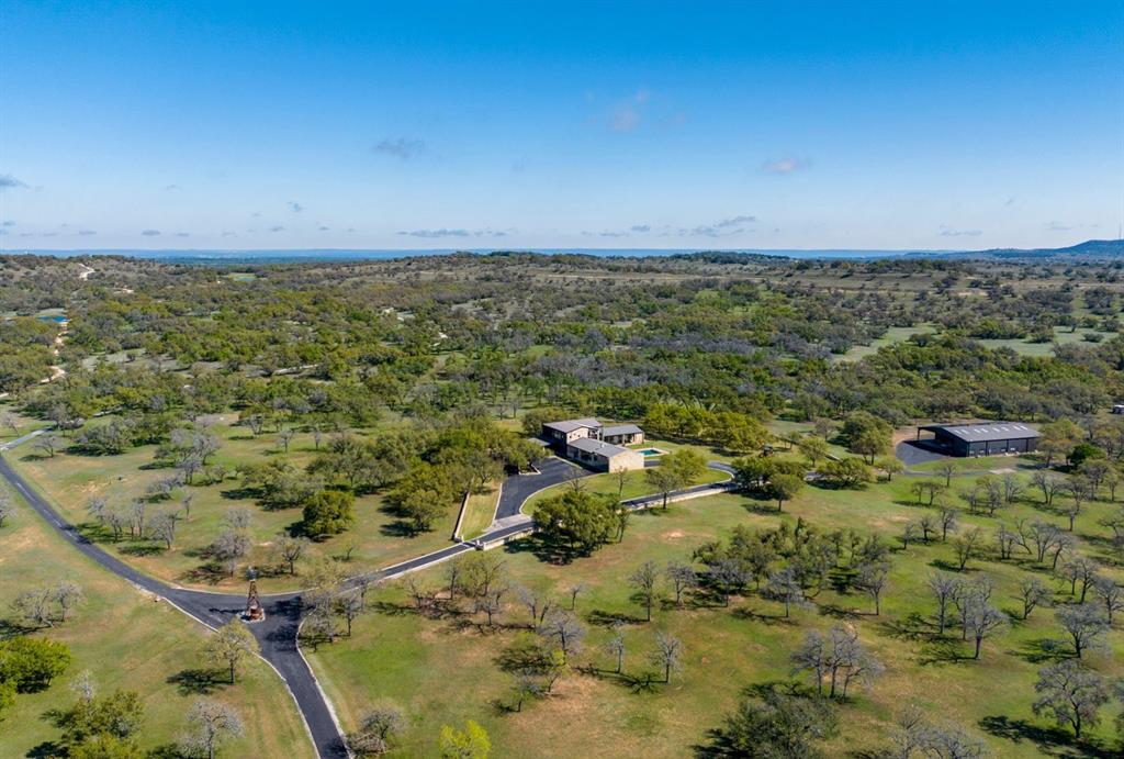 This 400-acre Hill Country ranch is located in highly desired Blanco County in the Cypress Mill area. Only 40 miles and less than an hour from Downtown Austin. Marble Falls, Johnson City and Horseshoe Bay are 15 minutes away. This stunning Texas ranch is one of the most desirable areas of the Hill Country.

This turn-key, unrestricted property is wildlife exempt, perfect for hunting, recreation, or potential event venue. With approximately 4,100 feet of frontage along RR 962 E and only 3 miles east of Hwy 281, the ranch offers excellent access and privacy. Upon entering, you will feel like you are entering a park, with a paved road winding through maintained grounds and hundreds of majestic live oaks. The ranch features dense wooded areas as well offering great habitat for wildlife. The rolling hills provide incredible breathtaking views. Partially high fenced on two sides, the ranch boasts two large lined ponds that remain full year-round.

The main residence spans 4,800 square feet and features six bedrooms, eight bathrooms. With hardwood floors, top-of-the-line appliances, and high-end finishes throughout, this home is perfect for entertaining family and friends. The luxury outdoor entertaining area includes a heated pool with a built-in cover, an outdoor kitchen, along with an outdoor fireplace.

In addition to the main residence, there is a well-appointed insulated barn approximately 5,500 sqft. The barn has three separate air-conditioned spaces including a full office with bathroom and an apartment, perfect for a ranch hand or full-time foreman.

The ranch is equipped with off-grid capabilities with 70% of the house running off solar energy. Also boasts 90,000 gallons of rainwater collection, the ranch features three wells that produce 20-30+ gallons per minute.