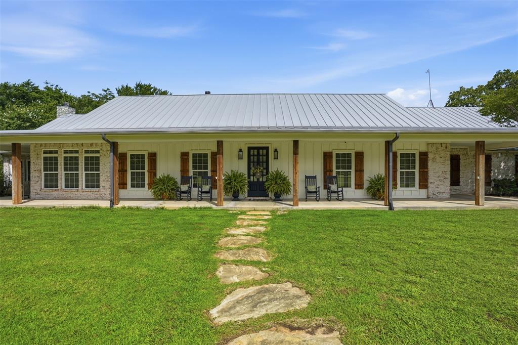 Tucked away on 21 pristine acres along a private stretch of Lake Granbury, this exceptional Texas Modern Farmhouse delivers the ultimate blend of luxury, land, and lifestyle. A long, tree-lined approach opens to a beautifully designed single-story residence with expansive porches, a standing seam metal roof, and timeless architectural appeal. Inside, the home is warm yet refined—featuring vaulted, wood-paneled ceilings, custom millwork, built-ins, and a stunning fireplace anchoring the main living space. The chef inspired kitchen is equally impressive with custom cabinetry, large double islands, high-end gas appliances, and an oversized butler’s pantry with private craft room, designed for effortless entertaining. Coffered ceilings, rich hand scraped hardwood floors, and thoughtfully curated finishes elevate every room. The private primary suite offers a true retreat with serene views and direct outdoor access, while additional living spaces provide flexibility for guests, work, or recreation. Step outside and experience what sets this property apart, multiple outdoor living areas including a covered wrap around patio, pergola, screened-in porch, and a striking stone fireplace gathering space. Overlooking the water and mature trees, every angle invites you to slow down and stay awhile. The land itself is a rare find, rolling pasture, scattered hardwoods, and a peaceful private lake setting complete with dock access. Ideal for recreation, livestock, or simply enjoying wide-open Texas skies. A metal insulated shop with electric, and ample space for expansion add to the property’s versatility. Whether you’re seeking a full-time residence, weekend retreat, or legacy property, this is a one-of-a-kind opportunity to own a private piece of Texas with unmatched character and setting. Private lake frontage of this caliber is rarely available. A true legacy property offering unmatched privacy, natural beauty, and refined living, just minutes from town yet worlds away.