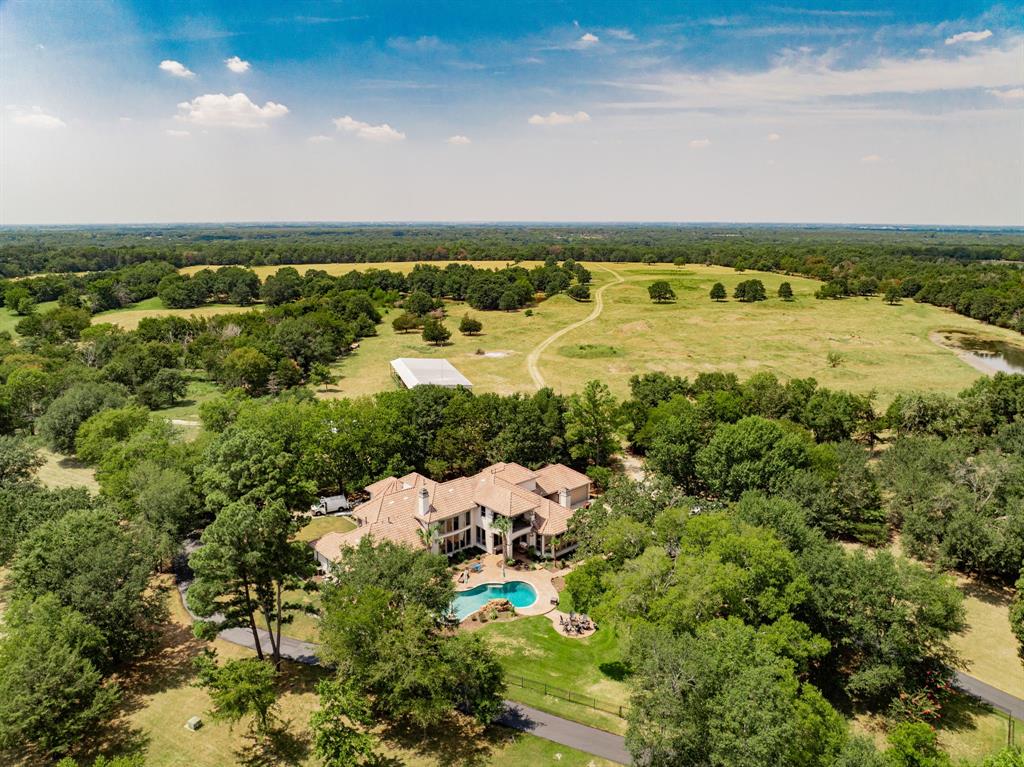 Minutes from downtown Dallas, this Premier 125.9 acre Gentleman's Ranch offers privacy and seclusion in style, with every modern amenity. Located in sought after Poetry, TX, this furnished luxury gated estate boasts a tastefully updated 6,566 sq. ft. mansion, complete with library, exercise room, game room, and media room, updated gourmet kitchen, large family room and elegant dining room, designed for luxury living, alongside a beautiful outdoor pool with spa and fire pit overlooking one of 2 large ponds. The estate features a completely renovated three-bedroom, two-bath farmhouse, a greenhouse, 2 barns and a large workshop building with RV and boat storage, recreation room and air-conditioned storage, offering ample space for various needs. The property is fully fenced and cross-fenced, with lush pastures, 2 ponds and 4 tanks, wooded areas, a small bunk house with AC, and well-maintained trails. Enjoy privacy with a gated entrance on a private road and additional adjoining acreage on a county road. Ideal for primary home, ranch retreat or recreational pursuits. This ranch is the only move in ready 100+ acre property available east of Dallas within commuting distance to downtown. Possible Owner Financing with favorable terms available with approved credit. Leave the world behind in style.