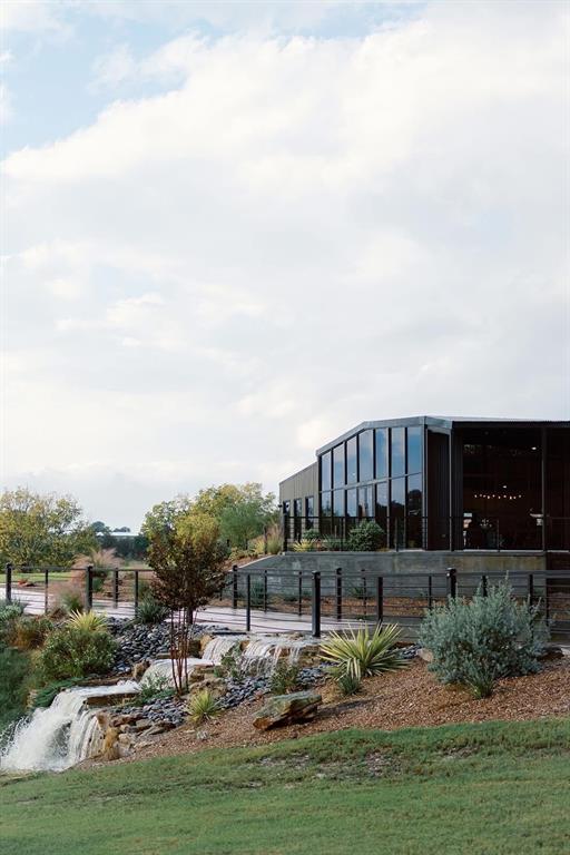 Beautiful modern venue sitting on acreage overlooking completely private 10 acre mini-lake. Great opportunity to jump right into business as it's already operable and has bookings into 2027. Sleek modern black exterior design separates this from any other venue in North Texas. Floor to Ceiling glass allows unmatched views of lake. Two completely separate units which also overlook water, current use is a Bridal suite and Groom Suite. Very fun and colorful interiors create an unmatched design unlike any other space. Built in 2023 so everything is completely new and beautifully designed. Large concrete bridge separates pond and lake with beautiful landscaped rock waterfall. Must see to understand how absolutely breathtaking this property is. Land also features a massive amount of road frontage on hwy 287. Also includes tons of acreage available to develop, build a house, cabins, motel, etc. Includes FF&E.