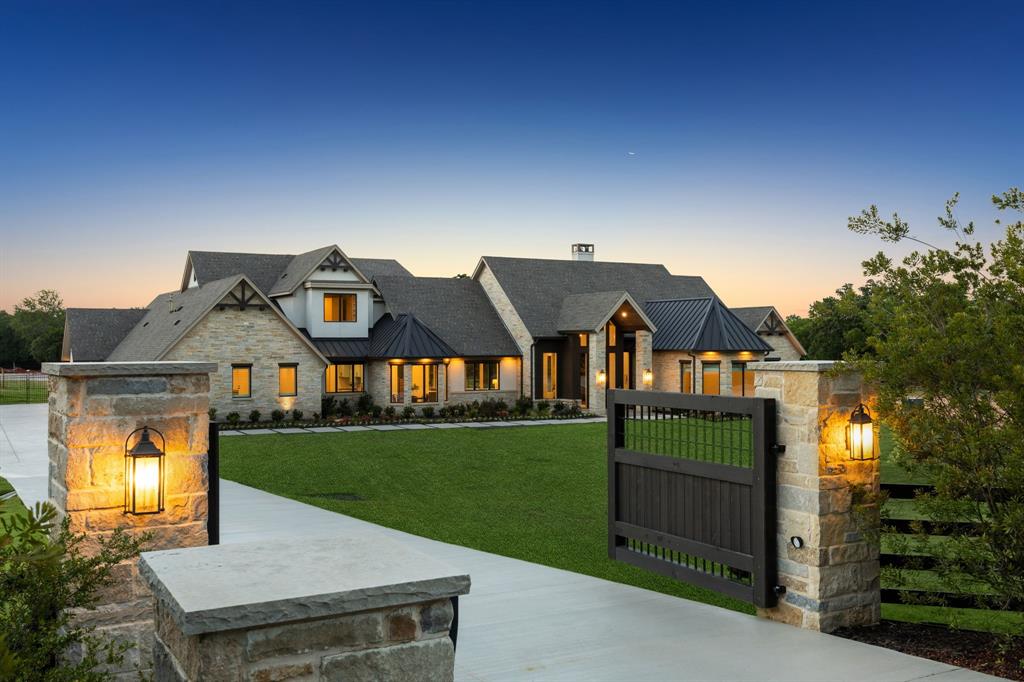 Reintroducing this 2021 custom built home with a newly configured 1.3-acre homesite, this transitional estate offers a fresh perspective, now without the barn acreage. Designed with balance and intention, the four-bedroom residence blends modern architecture with warm natural finishes, including 5-inch hardwood floors, hand-selected stone, and striking quartzites that soften its clean lines. Beneath soaring two-story pitched windows, natural light fills the home, framing views of the infinity-edge pool and expansive lawn. A dramatic great room with statement fireplace flows into an open dining area with a fireplace and pool views, creating an inviting setting for daily living and entertaining. The kitchen centers around a quartzite island with an oversized picture window at the sink, while a fully equipped scullery adds a second sink, dishwasher, double ovens, and separate 36-inch refrigerator and freezer. A glass-walled study overlooks the pool, while media and game rooms open to a 910-square-foot outdoor living space with electric screens, linear fire pit, and a fully equipped grilling center with an expansive island, all oriented toward the pool and lawn. The owner’s suite is privately positioned with views of the lawn and mature tree, featuring a fireplace, large windows, and en-suite bathroom with freestanding tub, double steam shower with rain head, and custom closet with glass-front cabinetry and hidden storage. A main-level guest suite overlooks the front grounds, where deer and wild turkeys roam. Upstairs, a loft with built-ins leads to a hidden ballet studio. Two additional bedrooms offer window seats, ensuite baths with walk-in showers, and spacious closets. A laundry room with island and dog wash adds convenience. Built with slab-on-pier construction, spray foam encapsulation, and a 20KW Kohler generator. Four-car garage with Versa lift and two golf cart bays. Open enrollment to Carroll ISD.