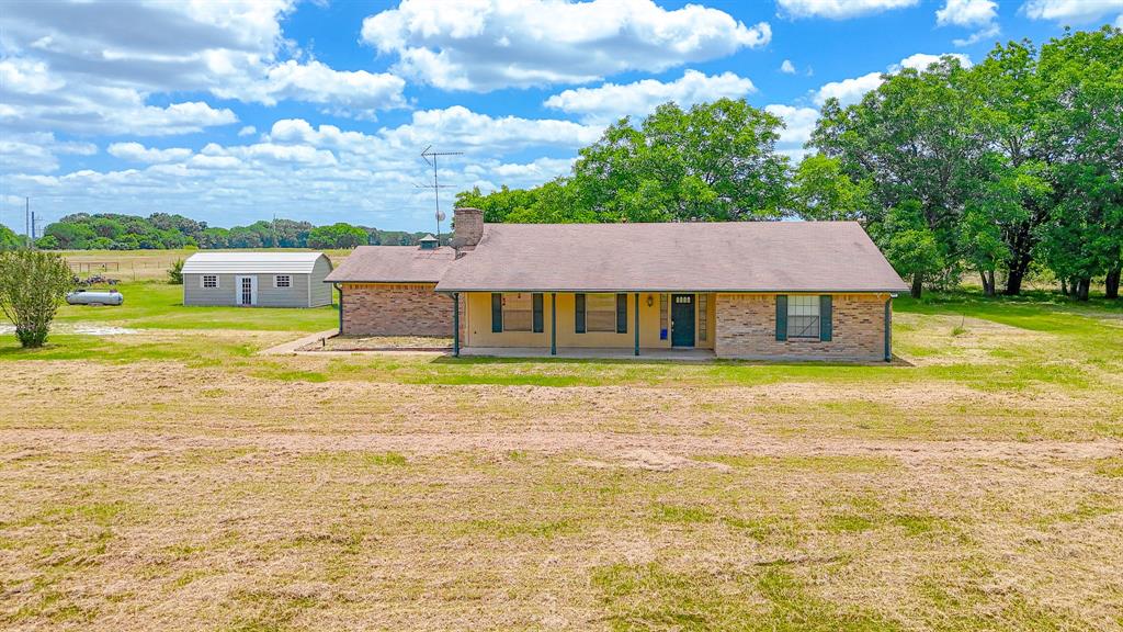 Escape to the peace and privacy of country living with this charming 3-bedroom, 2-bath home situated on approximately 4 acres. Set back from the road and surrounded by open space, this property offers a blend of comfort, functionality, and rural charm. Inside, you'll find a spacious living area featuring a beautiful brick fireplace with built-in shelving, creating a warm and inviting focal point. The kitchen offers ample cabinetry, generous counter space, and an open layout that flows into the dining area, making everyday living and entertaining seamless.
Enjoy covered front and back porches that provide excellent outdoor living space and views of the surrounding acreage. The fenced backyard offers a versatile area for pets, gardening, entertaining, and outdoor activities. A large shop and separate storage shed provide valuable storage, workshop space, or room for equipment and projects. With approximately 4 acres of land and plenty of room to spread out, this property offers endless possibilities. Conveniently located just minutes from Navarro Mills Lake, you'll enjoy easy access to fishing, boating, camping, and outdoor recreation while still being within reach of nearby communities and everyday amenities.