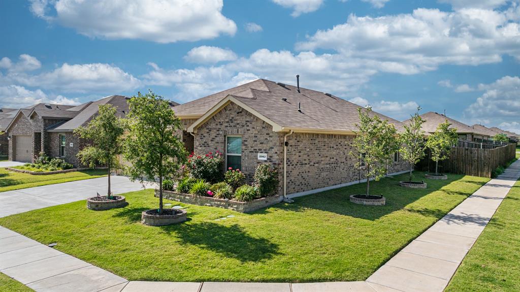 USDA eligible!! This newer construction single-story home on a corner lot features approximately 2,100 sq ft with 4 bedrooms, 3 full bathrooms, and a dedicated office. The layout is an open-concept design offering an electric fireplace with a large living area flowing into the kitchen and dining space, ideal for entertaining and everyday living. The kitchen includes quartz countertops, ample cabinetry, pantry storage, pendant lights, and a center island.
The primary suite offers a spacious bedroom, walk-in closet, dual or extended vanity space, and a walk-in shower. Interior finishes in similar homes include luxury vinyl plank in main living areas, smart home features, and energy-efficient systems. Exterior features include brick construction, a covered patio, sprinkler system, fenced backyard, and attached 2-car garage.
Community amenities in Valor Farms include a neighborhood pool, playground, and quick access to I-30, Buc-ee’s, schools, shopping, and dining in Royse City.