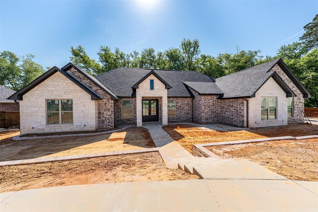 Experience refined living in this exceptional new construction home located in the sought-after Oak Creek Subdivision. Spanning over 2,600 square feet, this 4-bedroom, 2.5-bath residence blends timeless design with modern sophistication, with an anticipated completion of May 31, 2026.
The heart of the home showcases a grand family room with vaulted ceilings, exposed stained beams, and a dramatic floor-to-ceiling stone ventless fireplace. Designed for both everyday living and entertaining, the open-concept layout flows effortlessly into a chef-inspired kitchen featuring a gas range, separate electric oven, stainless appliances, an expansive island, solid surface countertops, walk-in pantry, and custom cabinetry, including elegant glass-front accents.
The private primary suite offers a serene retreat with a box ceiling and a spa-like bath complete with dual vanities, soaking tub, oversized walk-in shower, water closet, and generous walk-in closet. Three additional guest bedrooms share a well-appointed bath with double vanity.
Thoughtful details include black fixtures throughout, wood flooring in the primary suite, carpeted guest rooms, a functional laundry room with mud space, and abundant storage.
Step outside to enjoy a spacious screened-in porch and extended deck overlooking tranquil wooded views—ideal for relaxing or entertaining.
Additional highlights include a two-car garage and potential owner financing.
Mandatory membership to Tyler Athletic Club. Buyer to independently verify HOA dues, club fees, and available amenities.