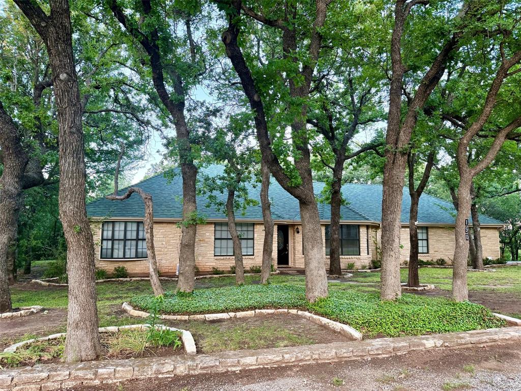 Unlock the door to your dream home with this property located on Timber Ridge Lake, Graham, Texas - Home provides excellent country living with 1.46 acres covered in trees all the way to the lake - Large wooden deck off the back of the home providing a very impressive view with country living & the lake views - Also walkway for access to lake - 3 bedroom home with 1.75 baths - Side entrance 2 car garage - Home has open concept floor plan - Large family room with fireplace & formal dining area – Kitchen has all built-in including refrigerator, free standing cookstove, dishwasher and microwave vent-a-hood - Large primary bedroom with walk-in closet and ensuite bathroom – One bedroom has built-in cabinetry which would make an awesome office – Home is total electric with city water to the house & water pump from lake to water yard - Separate storage building - Property taxes are $5,845. (with no exemptions)