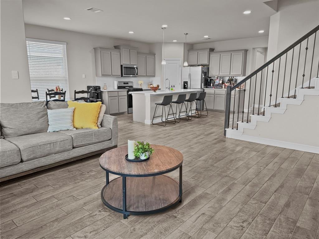 Don't wait for the timing of a new build! This spacious 5-bedroom, 4-full bathroom beauty is ready for new owners. Located in the sought-after Bluestem master-planned community, in award-winning Northwest ISD. As incentives, take advantage of the FHA 5.375 assumable interest rate, refrigerator, a 75 and 55 inch TV to convey. With two full bedrooms and 2 full bathrooms downstairs, 3 bedrooms and 2 full bathrooms upstairs makes this layout is perfect for a growing family wanting space or multigenerational living. You will experience BIG UPSTAIRS GAMEROOM and LOFT area—plenty of space for everyone to spread out and relax. The heart of the home is the open-concept living and dining area that flows effortlessly into the chef-inspired kitchen, featuring quartz countertops, stylish tiled backsplash, stainless steel appliances, a gas range, pendant-lit island, and a large walk-in pantry. Retreat to the luxurious primary suite complete with a dual-sink vanity, oversized walk-in shower, and a spacious walk-in closet. Other upgrades include: tankless water heater, designer extended tile flooring, smart home technology, partial gutters, front coach lighting, and more. Step outside to enjoy a peaceful covered back patio and fully fenced landscaped backyard with sprinkler system—ready for summer BBQs or quiet evenings. Enjoy all the amenities Bluestem offers: a resort-style pool, cabana, playgrounds, dog park, hiking trails, parks, and even a stocked fishing pond right at the entrance.
