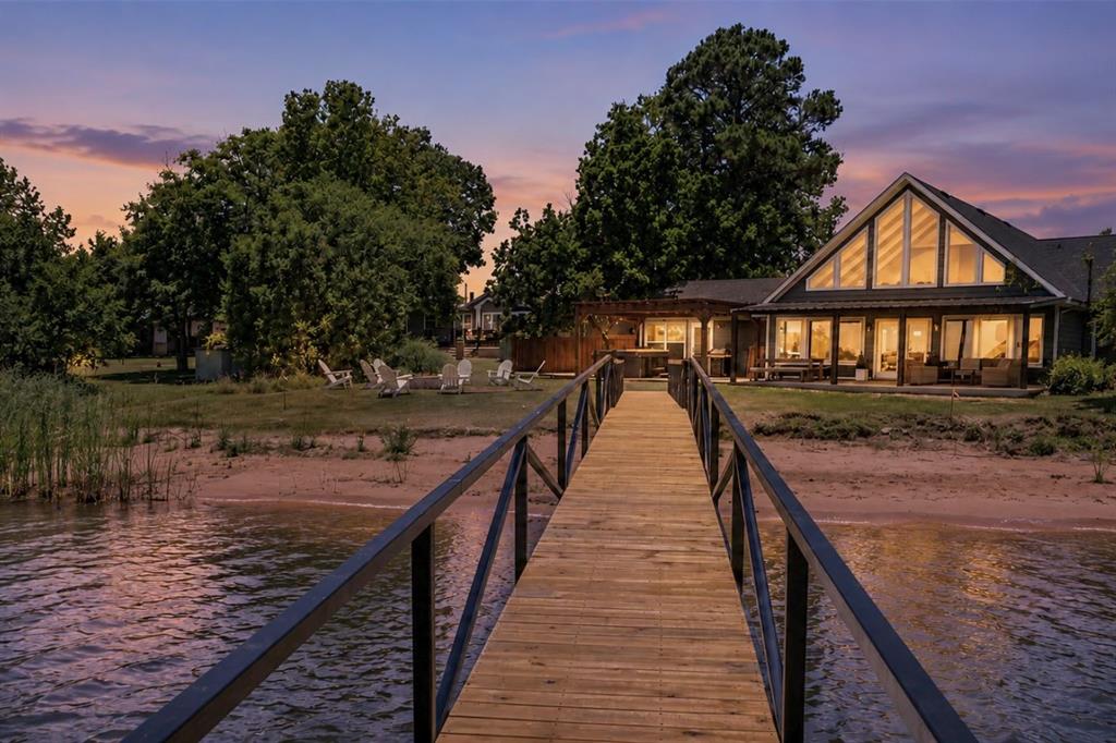 This luxuriously remodeled waterfront retreat, perfectly positioned in one of the most sought after areas of Possum Kingdom Lake, offers an exceptional blend of upscale lake living and proven income producing potential. Thoughtfully designed and impeccably updated, this turnkey property is being offered fully furnished, making it ready for immediate enjoyment or continued short term rental success. Inside, the home welcomes you with a bright and sophisticated open concept design featuring soaring vaulted ceilings, expansive windows, and a beautifully refreshed living area that seamlessly combines modern elegance with relaxed lakefront comfort. The inviting fireplace creates a warm focal point for gathering and entertaining, while the spacious layout offers effortless flow throughout the home. Recent enhancements include a stunning new back patio designed for elevated outdoor living, providing the perfect setting for entertaining guests, dining under the stars, or simply enjoying the breathtaking panoramic lake views. Upstairs, multiple flexible living and sleeping spaces comfortably accommodate family and guests alike. This property truly stands apart with its rare sandy beach frontage and newly added private boat dock, delivering direct access to the crystal clear waters of Possum Kingdom Lake and the ultimate luxury lake lifestyle. Beyond its beauty, this home is an established high performing short term rental with a strong presence on Airbnb and VRBO, offering immediate revenue potential for investors or buyers seeking a seamless turnkey opportunity. Whether you are searching for a luxury personal getaway, an income producing asset, or both, this exceptional waterfront property delivers on every level.
