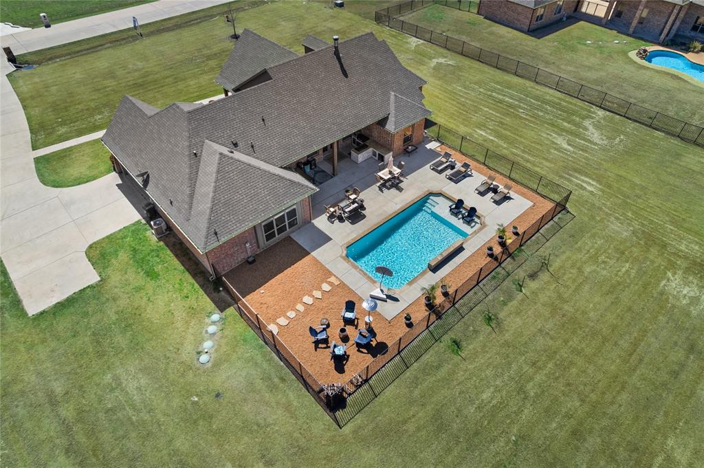 Hard-to-find 1-acre property in the gated community of Waterstone Estates offering one of the most accessible price points in the neighborhood and a unique chance to combine acreage living with significant monthly savings. This one-story home features soaring ceilings with exposed wood beams, a bright open-concept layout, and a spacious living area anchored by a striking fireplace. The kitchen is both functional and inviting, with white cabinetry, a large island, stainless steel appliances, and a walk-in pantry ideal for everyday living and entertaining. All new flooring installed March 2026 provides a fresh, move-in-ready feel throughout. The private primary suite offers a relaxing retreat with a soaking tub, dual vanities, and a generous walk-in closet. Secondary bedrooms are well-sized, and a versatile flex space can serve as a home office, gym, or additional living area. Step outside to a backyard designed for enjoying Texas evenings complete with a pool, expansive patio, outdoor kitchen, and wide-open views across your full acre. Located in Waterstone Estates, a gated community known for acreage homes and privacy, this property offers a rare opportunity to own land, space, and a significantly lower interest rate in today’s market.