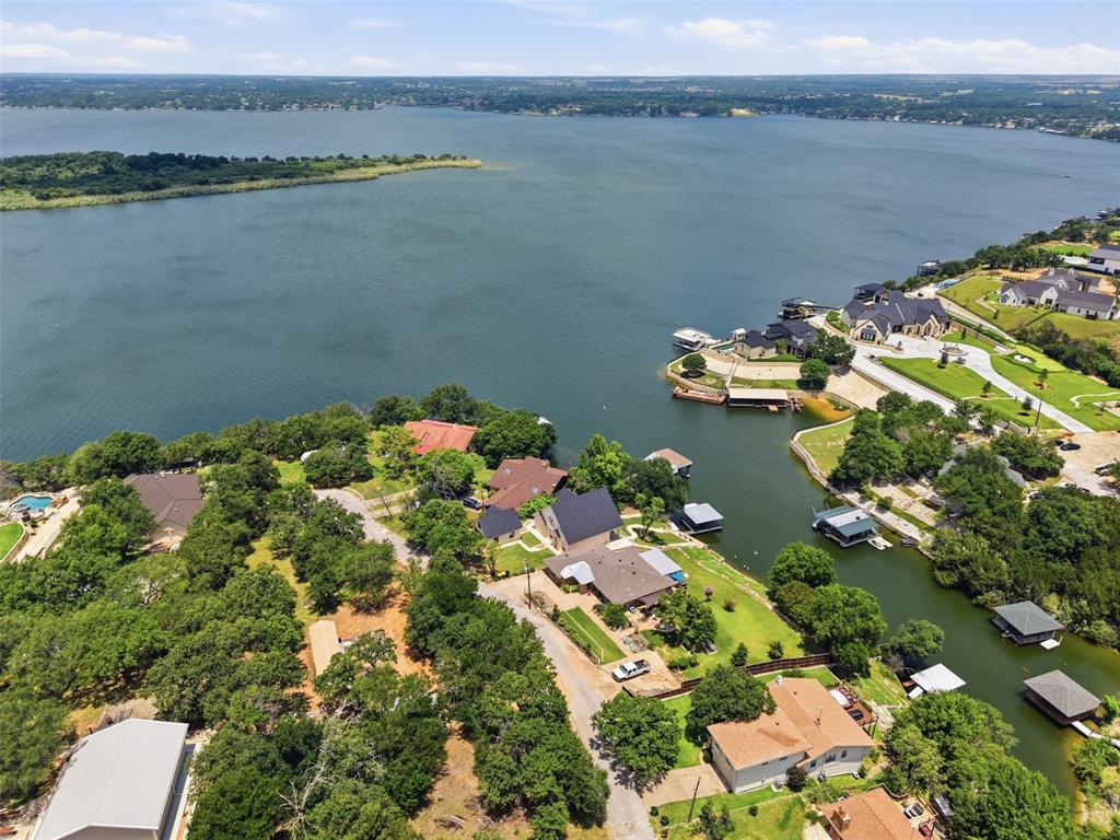 WATERFRONT NEWLY REMODELED with BOAT DOCK.....DEEP large cove 1 house from MAIN BODY.....5 BEDROOMS with 2 being PRIMARY BEDROOMS, 3 FULL BATHROOMS, 2 LAUNDRY ROOMS.....NEW ROOF.....Currently used as a short term rental so continue that or use as LAKE house or do BOTH!! NO CITY TAXES..No HOA....Updates include all new QUARTZ countertops in kitchen and bathrooms, quartz backsplash in kitchen with added under cabinet lights and outlets, new KITCHEN sink faucet and garbage disposal, new flooring downstairs, ALL 3 bathrooms are NEW, fans, lights, mirrors, bathroom hardware, doorknobs, paint downstairs, exterior paint including boat dock, hot water heater and more...Large BALCONY and covered patio to take in the water views......2nd level in garage with decking for storage or make into living space or Gameroom etc.....all rooms down except for one bedroom, one primary bed and bath, one laundry and balcony.....light and bright with tall ceilings and windows......Primary down has a private door to large covered patio.....low maintenance boat dock with trex flooring...AC's just serviced...Only 34 minutes from Fort Worth or 16 minutes from Granbury's town square where you can enjoy shopping, great food, theatre, events, shows, live music, walking paths, museums and much more!!!