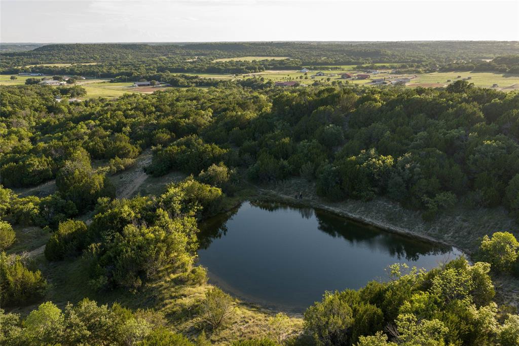 1,717 characters. All clean. Here's the updated 283 listing:

±283 acres on US Highway 281, fourteen miles north of Stephenville in Erath County. A legacy ranch tract carved from the historic Jordan Ranch and held in single-family ownership for the past twenty-eight years.
The land has 1,300 feet of US Highway 281 frontage with a gated entrance. Elevation rises from 1,090 to 1,260 feet, with high ground and panoramic views in every direction. Cleared pasture in Coastal Bermuda and native bluestem opens through heavy mature live oak and hardwood timber. Native tree cover includes live oak, post oak, and mesquite. A seasonal creek and natural drainage run through the property. The high ridge at the top of the ranch is locally known as Buck Ridge, named for what comes off it. Multiple build sites with views in every direction.
The land has supported a small cow-calf operation for more than twenty years.
Water comes from one working well producing 12 gallons per minute or better. The well feeds a working windmill that supplies cattle troughs. One spring-fed stock tank.
Wildlife is abundant. Whitetail deer, Rio Grande turkey, and dove are all present, along with coyotes and bobcats. The property has seen very low hunting pressure for the last five years. The current owners have hunted lightly, taken what was needed, and let the rest grow. Existing hunting infrastructure includes two bow stands, one box blind, and three feeders.
The land carries an active agricultural exemption. The Dallas Fort Worth Metroplex is approximately ninety minutes east.
This tract is part of a 319 acre legacy property offered three ways. The custom home is available separately on approximately 36 acres, or with the full 319 acres including the home. For full info visit kdranch.info.