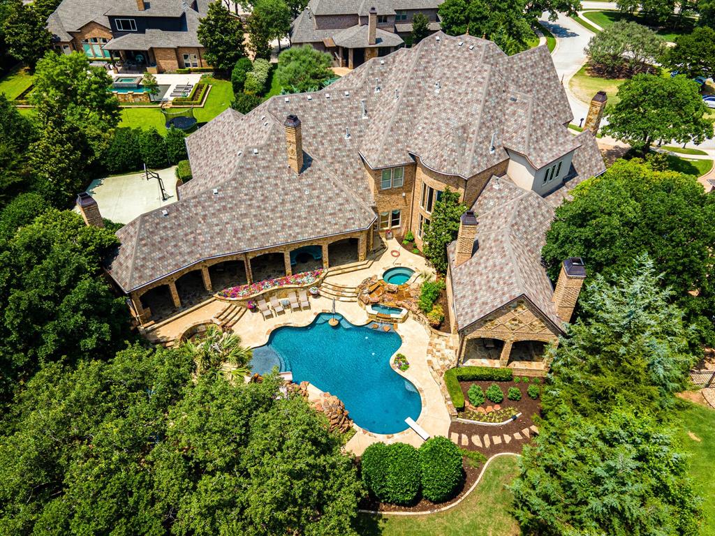 Magnificent luxury estate in highly desirable Westwyck Hills! This updated and well appointed property with generously sized rooms provides the backdrop for creating priceless family memories and entertaining large gatherings. Chef’s kitchen, featuring double Wolf 6 burner gas range, dual Sub Zero fridge, and two dishwashers, opens to Family Room with wall of windows overlooking the private backyard retreat. Coveted downstair’s theater and gameroom are situated conveniently off the Family Room. Primary Bedroom suite features luxurious bath and private covered porch overlooking the pool area. Additional primary suite located downstairs. Four spacious ensuite guest rooms along with utility room, game room and gaming space located upstairs. SPECTACULAR resort style backyard featuring incredible pool, spa, fire pit, outdoor kitchen and living area, professional lighting system...and more, provides a wonderful place to cool off in the hot Texas summer! CARROLL ISD.