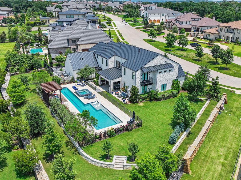 Welcome to this custom estate in Westlake's guard gated Granada! This custom-built luxury residence boasts modern finishes & amenities + open plan living. Step through the beautiful Iron door to a gorgeous view through to the backyard oasis. Stunning center beam floating iron w wood tread staircase + stacked limestone feature wall, Wows! Great Chef’s Kitchen is fully equipped w professional Thermador appliances, 2 dishwashers, built-in fridge, gas range double oven, microwave & warming drawer. Prep Kitchen w 4-bottle Dacor wine dispenser and full wine fridge tower. Opportunity for 2 Primary Suites one on each level boasting spa like baths. Laundry rooms upstairs & downstairs. Exquisite home also offers a storm shelter, water filtration system, auto shades downstairs  + plantation shutters up. Summer living at its best in the outdoor oasis complete w kitchen, fire pit, sparkling Claffey self-cleaning pool & spa, large grass play areas, numerous sitting areas + views of neighborhood lake