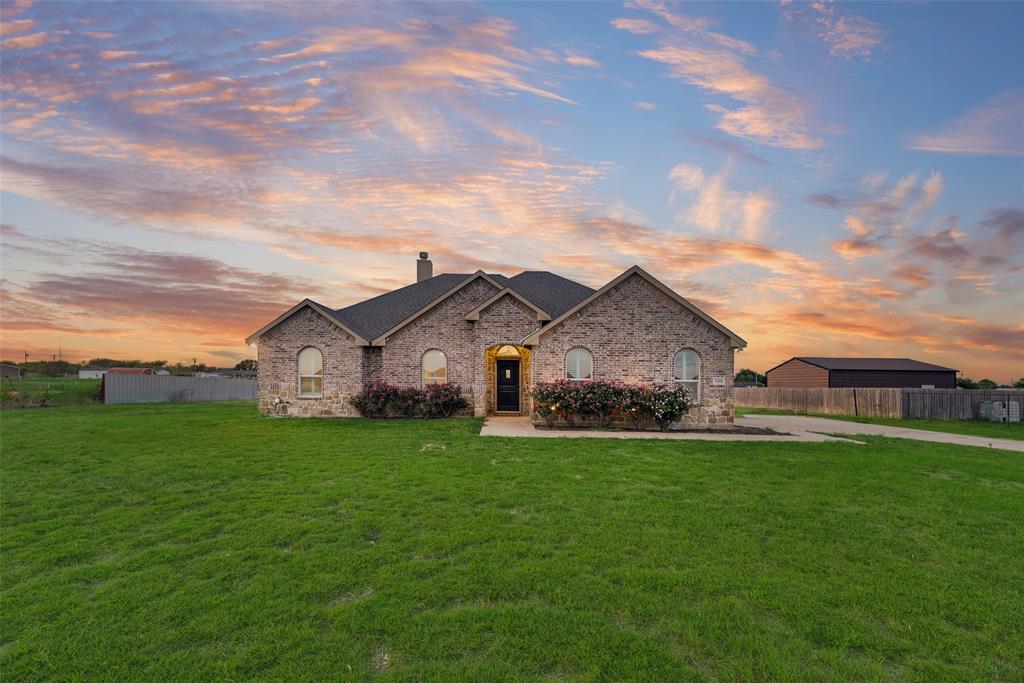 Welcome to this stunning brick and stone home nestled on a spacious 1-acre lot with NO HOA, offering the perfect blend of comfort, style, and room to grow! From the moment you arrive, you'll appreciate the impressive curb appeal, side-entry garage, concrete driveway, and welcoming concrete walkway leading to the front entrance. Step inside to discover a bright, open floor plan featuring beautiful wood floors, elegant shadow box ceilings, and a striking stone-and-brick wood-burning fireplace that creates a warm and inviting focal point. The thoughtfully designed mudroom adds everyday convenience, while the spacious kitchen is sure to impress with custom-built cabinetry, gorgeous granite countertops, a gas stove, and plenty of workspace for cooking and entertaining. The sunny dining area and breakfast nook are filled with natural light thanks to charming bay windows, creating the perfect space to enjoy your morning coffee or gather with family and friends. The private primary suite offers a relaxing retreat with an ensuite bath featuring dual granite vanities, a glass-enclosed separate shower, and a large walk-in closet. Step outside to the covered 14' x 9' back patio and imagine the possibilities! With a full 1-acre lot, there's plenty of room to build your dream pool, create an outdoor entertaining oasis, add a workshop, or simply enjoy the wide-open space. Conveniently located just minutes from local grocery stores, shopping, dining, and family-friendly parks, this home offers the peaceful feel of country living while being just outside the Dallas–Fort Worth Metroplex, providing easy access to everything the area has to offer. If you've been searching for a home with space, quality craftsmanship, modern comforts, and the freedom of no HOA, this exceptional property is one you won't want to miss!