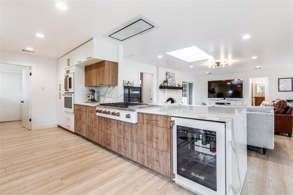 Sleek and crisp, this totally renovated home is packed with luxury updates and situated in a vibrant, established neighborhood. Not a flip, over 300K was spent on luxury cosmetic upgrades plus structural and mechanical improvements over the past five years. The open floor plan is a showstopper from the moment you enter the front door. The light-filled and expansive living, dining, and kitchen area offers endless opportunities for everyday living and entertaining. Luxury vinyl plank flooring connects all living areas and bedrooms. You'll love cooking in the stunning kitchen, which features Vicostone quartz countertops, GE Cafe Appliances, including a double convection oven, a recessed ceiling mount vent, and a 6-burner range with griddle. Custom cabinetry offers plenty of drawers. All three full bathrooms flow seamlessly together with similar finishes: new vanities, quartz countertops, classic tile, and new fixtures. Literally ripped down to the studs, other extras include vinyl windows, AC, sheetrock, ductwork, plumbing under the house, recessed lighting, and hardware and light fixtures throughout. Outside, the large backyard is surrounded by a stained horizontal fence and an electric gated driveway. Foundation and drainage improvements, too! For a complete list of improvements, see the transaction desk. With top-rated and desirable RISD schools nearby, that sense of community you've been craving can be found here. Great retail and restaurants are nearby. Less than 14 miles to downtown Dallas with two major highways nearby, it's a commuter's dream.