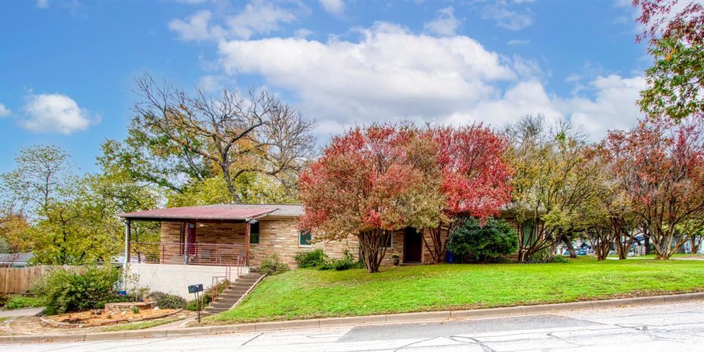 Don't miss the opportunity to live in this charming 1952, stacked stone home nestled on a hillside corner lot in the River District along the Trinity River. Captivating curb appeal w-an abundance of Crape Myrtles, spiral stone landscaping & 2 covered front entries. Step inside to solid white maple flooring & enjoy the warmth of the stacked stone, wood burning fireplace, encompassing living room  & den. Kitchen boasts floor-to-ceiling cabinetry, granite, original GE® stove, Ranger® vent & breakfast area. Utility room w-lots of storage. Bedrooms showcase solid oak flooring, double-door closets w-built-in dressers & shelving, en-suite bath, & full bath. Step off the wood deck into the backyard w-mature trees, fencing, & 2 car garage. Enjoy evening walks on the extensive trail system. Walkable neighborhood w-cafes, retail & entertainment adding to the allure of this remarkable community. Storage shed, refrigerator, washer, & dryer conveys. No HOA. Search address in YouTube for video.