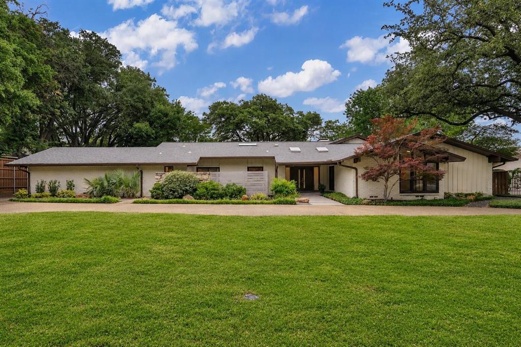 Welcome to 6943 Prestonshire Lane, a stunning Mid-Century Modern home located in the heart of Dallas that is truly perfect for entertaining. Upon entering, you'll be greeted by a dramatic living room with vaulted ceilings, skylights, terrazzo flooring, a striking stone fireplace, and a wet bar. Enjoy views of the beautifully landscaped backyard and sparkling pool from multiple living spaces.  The updated kitchen offers an oversized island, quartz countertops, skylight, six-burner gas cooktop, and Sub-Zero refrigerator. A second living area also overlooks the backyard and features skylights and terrazzo flooring, creating a bright and inviting atmosphere. The oversized primary suite is a true retreat with its own fireplace, luxurious bath featuring marble flooring, large walk-in shower, spacious custom walk-in closet with built-in cabinetry, and private access to the backyard. A dedicated office with built-in shelves, desk, and closet can easily serve as a fifth bedroom. Additional highlights include a three-car garage and extra parking space in the rear for multiple vehicles. The backyard is designed for relaxation and entertaining, featuring a covered patio area, perfect for enjoying drinks, dining, and gathering with family and friends.
