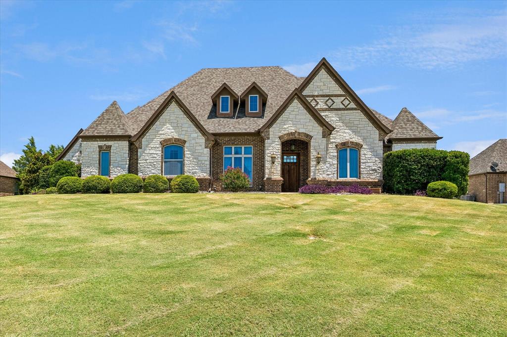 Welcome to Vista Ranch, where luxury meets comfort in this beautifully crafted home on 1.2 peaceful acres. From the moment you step inside, the warmth of hardwood floors and the charm of exposed wood beams set the tone for a home that feels both elegant and inviting.  The living room centers around a stunning stone fireplace, creating a cozy gathering space that flows seamlessly into the chef’s kitchen. With granite counters, double ovens, stainless appliances, a gas cooktop, and a pot filler, this kitchen is built for cooking, hosting, and everyday living. The large main-level primary suite offers a quiet escape with a spacious walk-in closet and thoughtful built-ins. Two additional bedrooms are tucked away near the mudroom, providing privacy for family or guests. Upstairs, the great room—complete with custom cabinetry—and the media room offer endless entertainment possibilities, along with a fourth bedroom ideal for visitors. Practicality meets luxury with a 3-car garage and a 30x40 pad ready for your dream workshop or additional garage. Energy-efficient upgrades—including foam encapsulation, tankless water heaters, and a Class 4 roof—keep monthly expenses low. And with no water bill and no city taxes, this home offers exceptional long-term value.
