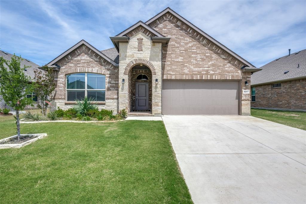 This is a short sale subject to lender approval.  Welcome to this beautifully maintained single-story home offering a bright, open layout and modern finishes throughout. The inviting exterior features a blend of brick and stone, a covered entry, and clean landscaping that sets the tone for the rest of the home. Inside, you’re greeted by warm natural light, neutral colors, and durable wood-look tile flooring that flows through the main living areas.  The open-concept kitchen and living space is the heart of the home, featuring light gray cabinetry, stainless steel appliances, a gas range, a large island with seating, pendant lighting, and a spacious dining area. The living room offers generous windows, a ceiling fan, and plenty of room for comfortable everyday living or entertaining.  The private primary suite includes a large bedroom, walk-in closet, and a stylish ensuite bath with dual sinks, a wide vanity, and a glass-enclosed shower with tile surround and built-in bench. Additional bedrooms are well-sized with neutral tones, soft carpet, and great natural light—perfect for family, guests, or a home office. A built-in desk nook adds convenient workspace, while the separate laundry room and attached two-car garage provide practical storage options. Step outside to a fully fenced backyard with a covered patio, lush lawn, and room to play, garden, or relax. Located in Krum ISD with easy access to nearby amenities, this home blends comfort, function, and modern style in a peaceful neighborhood setting.