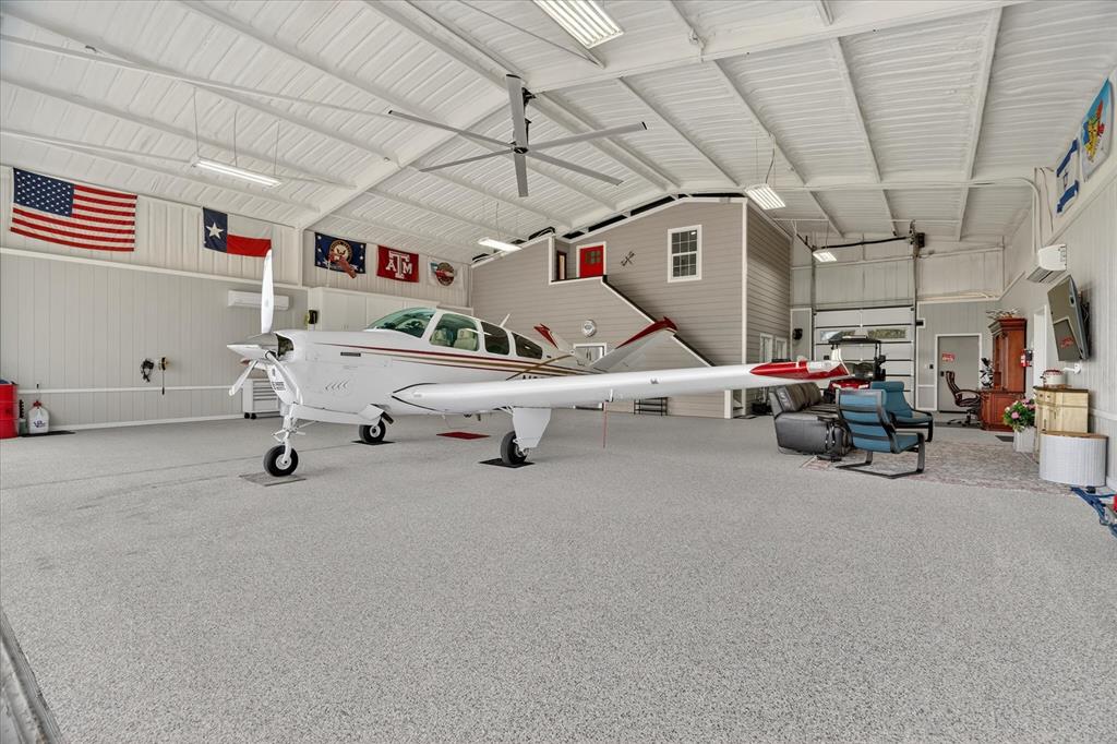 Rare Turnkey Fly-In Luxury at The Landings Airpark (66TE). Why spend 300K+ on a hangar alone & 12mo+ building when you can taxi home today? Located behind the gates of Pecan Plantation, this custom estate features direct concrete taxi w RNAV approach, PCL, & VASI. The ultimate pilot's setup includes a pristine, fully climate controlled 3,000 sq ft (50x60) hangar insulated w hard cell foam, textured epoxy, MacroAir fan, custom backlighting, Schweiss bifold door (42 ft W, 10'10 H)accommodating a Cirrus SR22, SF50, Bonanza, Baron, & Cessna 210. Workshop w full bath, 110 amp service, 220V plug, a built in dust collection system, & air compressor with three drops. Above the shop, separated by a sound insulated wall, is a fully finished 463 sqft apartment with a king size bedroom, full bath, living area, & kitchen. This is a true apartment, not guest quarters, with full separation from the main home, ideal for multi generational living or extended guest. The main residence offers 3,711 sq ft with an open layout and elevated finishes including hardwood flooring, granite surfaces, upgraded lighting, & custom details. The home features 3 bedrooms, 2 full baths, & one half bath, with each guest bedroom offering its own vanity & sink. A 294 square foot bonus room with a walk in closet & sink can serve as a 4th bedroom, office, or media space. The primary suite connects through the oversized closet directly to the utility room. Additional highlights include a two year old roof, tankless water heater, foam insulation, new dishwasher, French drains, generator hookup in the three car garage, stained concrete, covered walkways to the hangar, & landscaping. The layout keeps the hangar and home connected so your aircraft, RV, boat, & equipment are part of your daily routine. Located just 35 miles from FW & home to one of the most active EAA chapters in the country, this is more than a hangar, more than a home, it is the lifestyle you deserve!