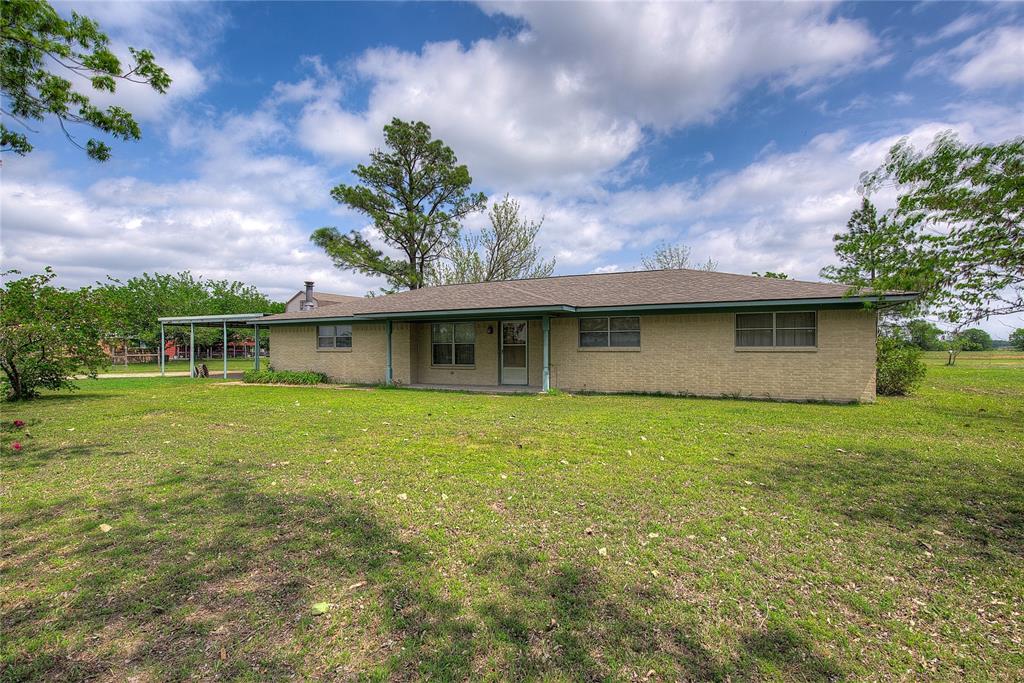 Enjoy the peace and privacy of country living with this charming ranch-style home situated on a full acre just outside the city limits. This classic three-bedroom, two-bath residence offers both comfort and flexibility, with spaces that can easily adapt to your lifestyle.

Step through the front door into the original living area—an ideal spot for a home office, music room, or play space. The converted garage adds a spacious family room perfect for relaxing or entertaining, while the enclosed back porch has been transformed into a bright and inviting sunroom, offering year-round enjoyment of the surrounding property.

The galley-style kitchen features a functional peninsula, built-in shelving, and abundant cabinetry, flowing seamlessly into the dining area—perfect for everyday living and gatherings. Just off the kitchen, a separate utility room provides a convenient space for a washer and dryer.

Outside, you’ll find plenty of room to spread out and pursue your hobbies. A two-story storage building provides excellent potential as a workshop, hobby space, or craft studio, and the additional shed is perfect for storing lawn and garden equipment. The attached two-car carport adds convenience and protection from the elements.

With friendly neighbors and room to breathe, this property delivers the best of quiet country living with the convenience of nearby amenities. Don’t miss the opportunity to make it your own.