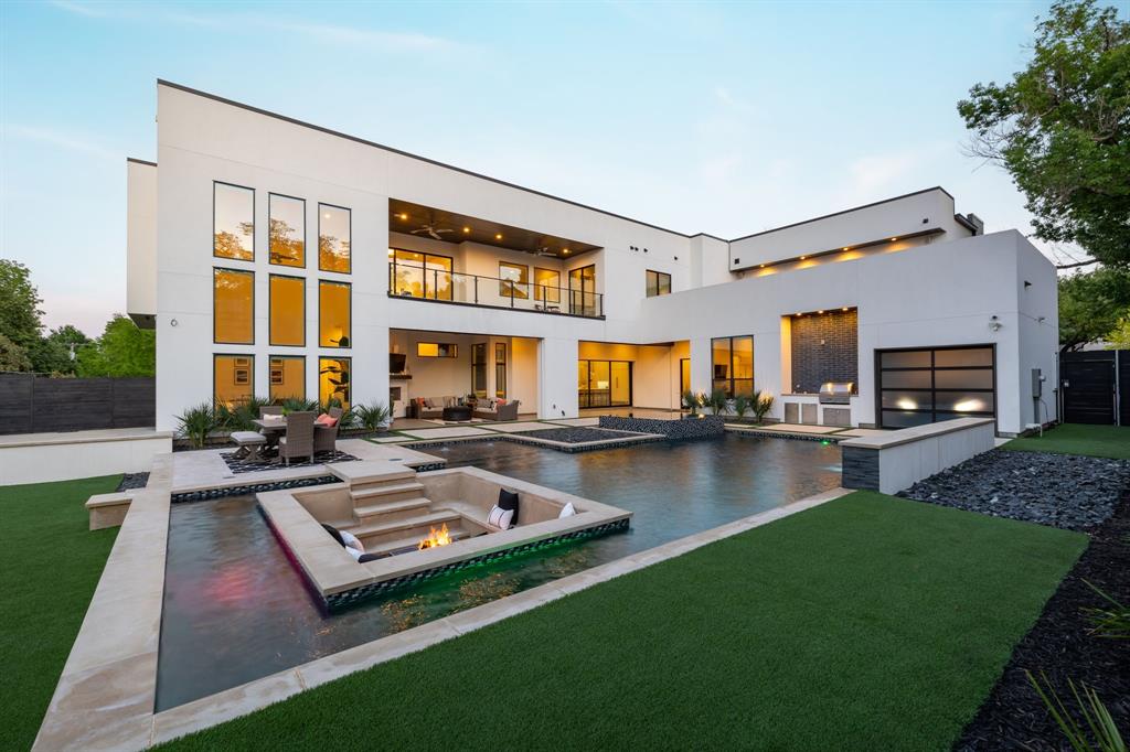 Modern masterpiece completed in 2021. Resort style living in the fairway of Preston Hollow with an open floor plan offers flexible spaces for work, play & entertainment. 30' wall of windows in front & back with soaring ceilings throughout. The heart of the home is the Wolf and Sub Zero kitchen, accompanied by full catering kitchen, 2 walk-in pantries, wet bar, temp-controlled wine room & butler's pantry. The owner's suite with fireplace, private laundry & coffee bar plus 2 ensuite bedrooms are located downstairs. 2 oversized secondary bedrooms, media room, playroom, office, game room with bar, & 2 terraces overlooking the pool are upstairs. Rooms have flexibility to grow with the owners needs. Aquaterra pool with waterfall, sunken lounge & fire pit, spa & in-ground trampoline all illuminated by LED lights. This property embodies modern luxury, functionality and privacy! Convenient location to the Dallas North Tollway, Preston- Royal amenities & the private school corridor.