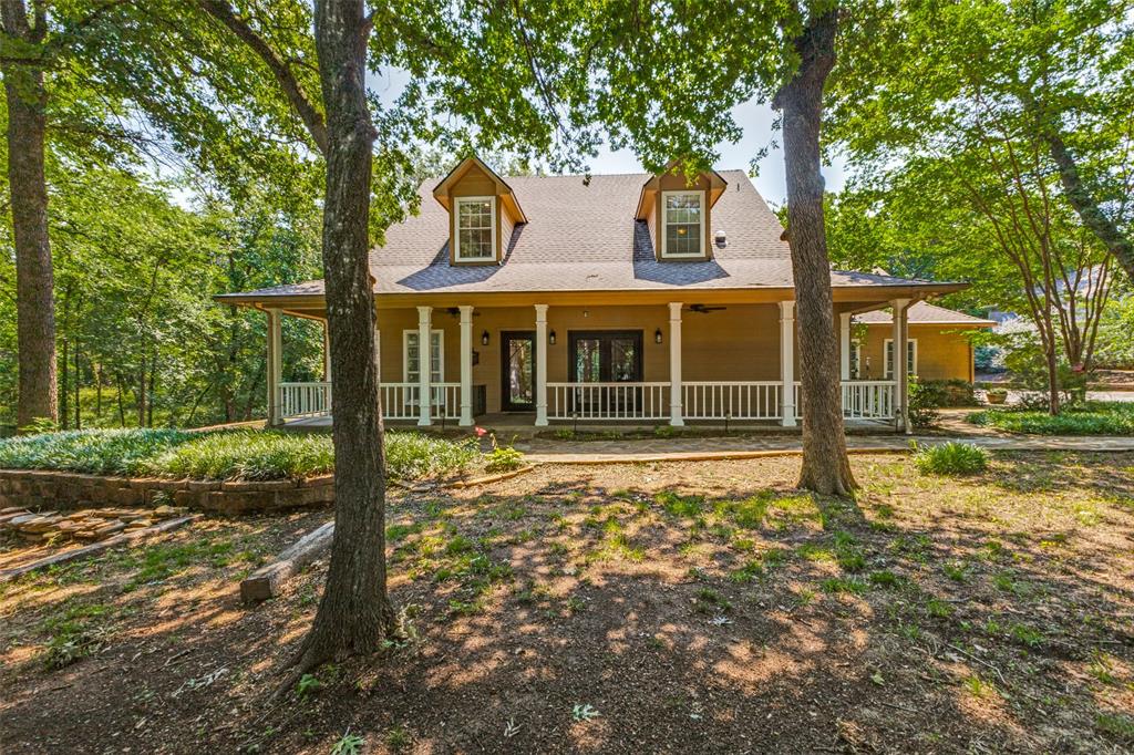 Beautifully updated 5 bedroom, 5 car garage country home on one acre! Offering the perfect blend of scenic serenity and modern sophistication, this exceptional estate commands attention with amazing curb appeal featuring a gorgeous walkway that leads to an expansive front porch and striking iron front doors. Inside, beautiful flooring runs throughout the inviting living spaces. The spacious family room features a cozy fireplace, while the formal dining room opens to the oversized front porch through iron French doors, creating an ideal setting for indoor-outdoor entertaining.  The updated chef’s kitchen is designed for both style and function, showcasing spectacular granite countertops, a center island with wine fridge, double GE Wi-Fi ovens, Samsung refrigerator, Bosch dishwasher, and Fisher Paykel gas cooktop. Storage is abundant with an extra-large butler’s pantry plus a second large pantry. A separate second family room showcases a beautiful stone fireplace and peaceful views of the surrounding outdoor space. The large primary bedroom serves as a private sanctuary, complete with a third fireplace and lovely views of the treed property. The primary bathroom offers a frameless glass shower, dual vanities, a garden tub, and plenty of natural light. A second bedroom on first floor is perfect for guests or family, and three additional bedrooms upstairs offer so much flexibility!  The park-like backyard includes a versatile, recently renovated, air-conditioned outbuilding that could serve as a home office, studio, or flex space to suit your needs. Wonderful lighted driveway leads to the massive FIVE CAR garage featuring epoxy floors. Countless premium upgrades have been completed over the past few years, including whole home air purification system, 16-SEER HVAC, fresh paint, updated flooring, extensive landscaping, and a tankless water heater. This meticulously maintained property offers the rare luxury of true country acreage with everyday conveniences nearby.
