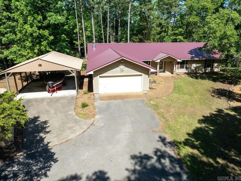Discover the possibilities in this spacious 4-bedroom, 2.5-bath home offering over 2,400 square feet of living space and the perfect setup for lake living or investment potential. With two separate living areas, there’s plenty of room for entertaining family and friends or creating flexible spaces to fit your lifestyle.  Tucked away at the end of the street, this property offers added privacy and a peaceful setting to relax and enjoy. A new metal roof installed in 2025 provides lasting value and peace of mind. The oversized 2-car garage plus an additional carport gives you ample space for vehicles, boats, and outdoor equipment.  Whether you're searching for a full-time residence, weekend lake getaway, or income-producing investment property, this home is packed with opportunity and priced to sell quickly.  Don’t miss your chance—schedule your showing today!
