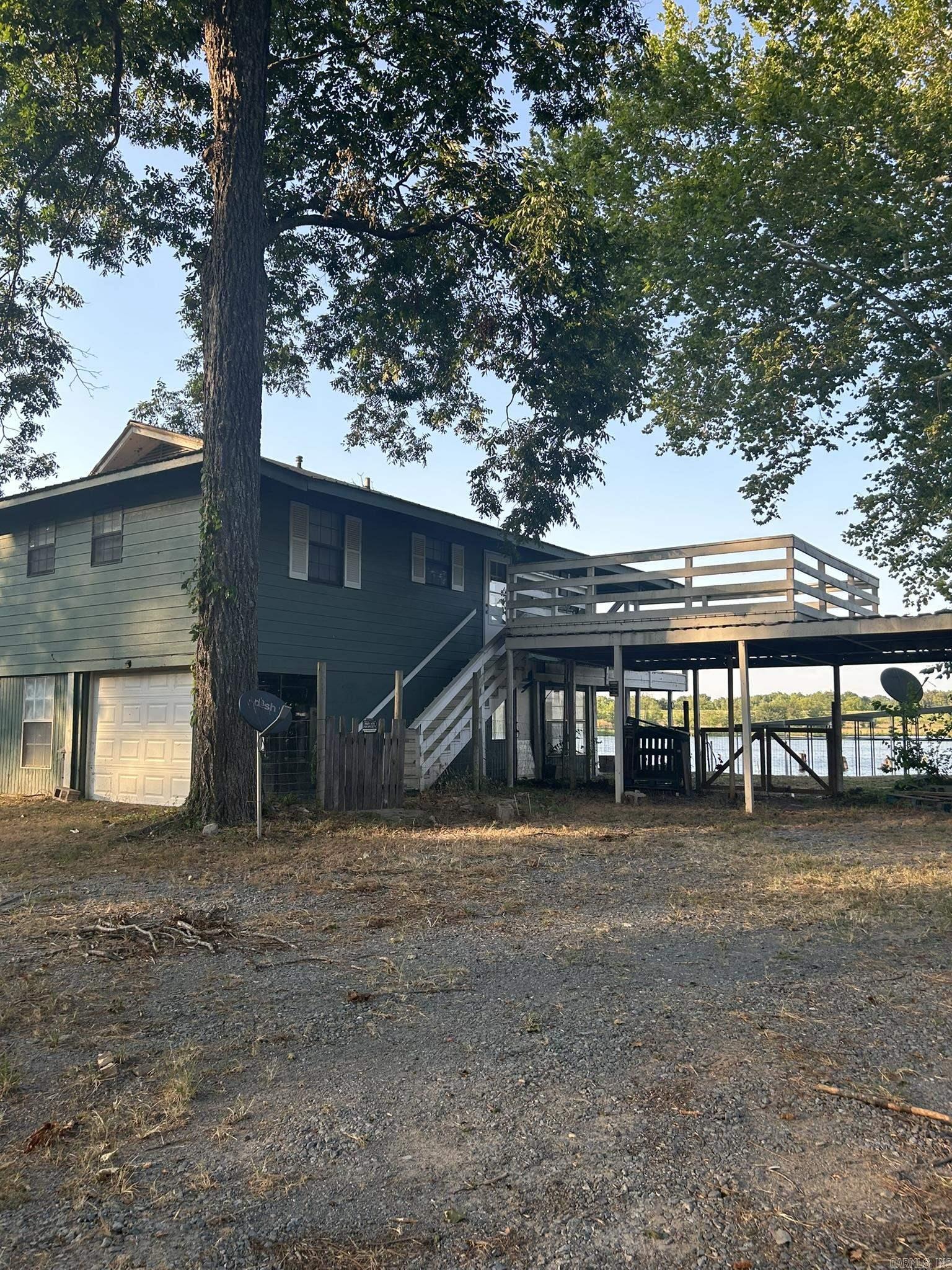 Arkansas Riverfront living on 1.45 acres! This property includes a 2-story home plus the adjoining lot, offering extra space and future potential. Features include a huge private boat dock, wrap-around balcony, oversized party deck, covered parking, and an unfinished lower level ready for your personal touch. Plenty of room for expansion, additional living space, or future building opportunities (buyer to verify). Located in a riverfront neighborhood with a community boat launch, this property is ideal for enjoying boating, fishing, entertaining, and the river lifestyle.