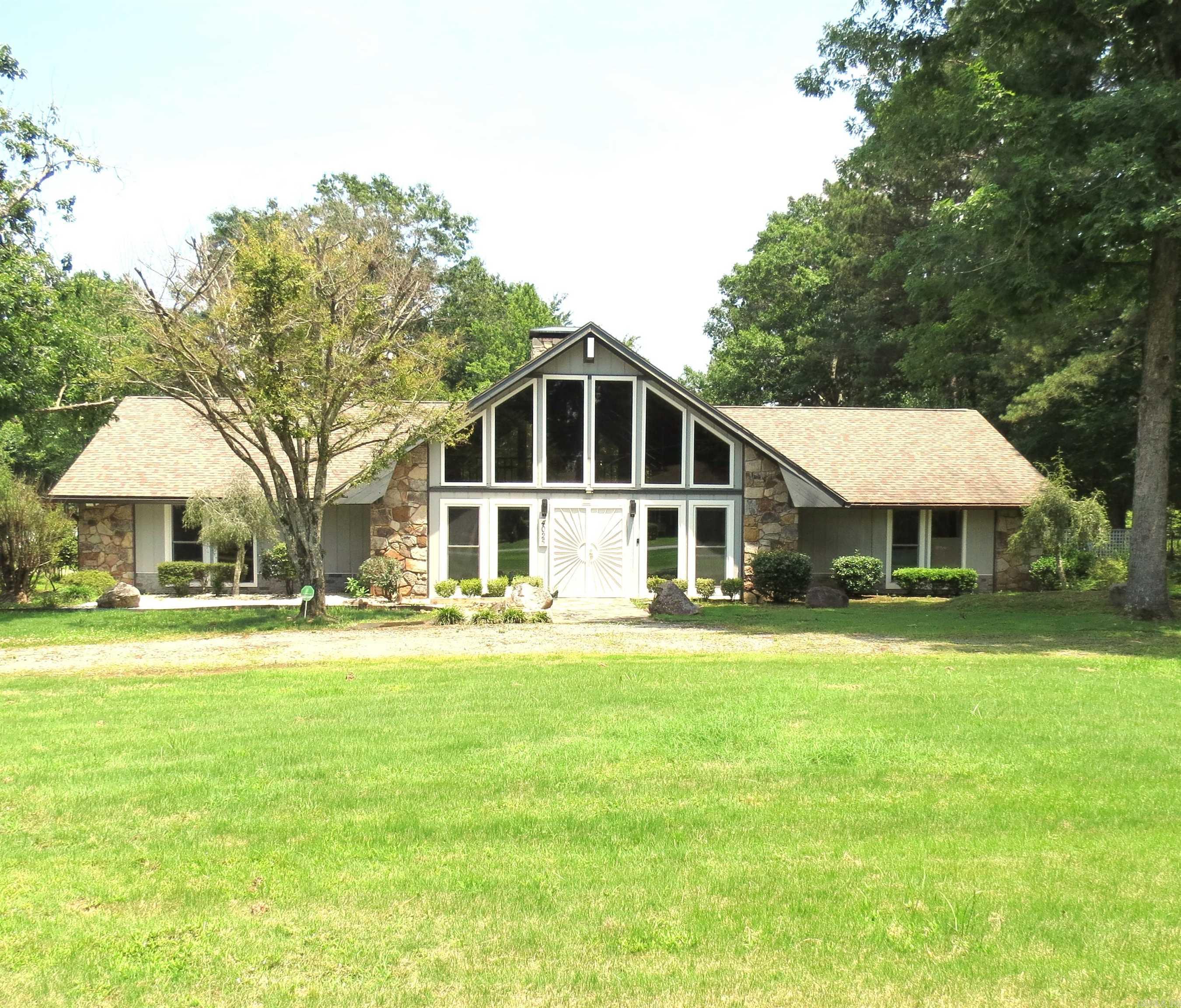What a Beauty!! So many features Large new windows downstairs!!  Vaulted wood ceiling with a beautiful rock fireplace with electric logs.  Loft upstairs.  Beautiful kitchen with Granet countertops, lots of cabinets with pull outs, 6 burner cooktop, double oven, under cabinet beverage cooler, large island, ss appliances, refrigerator stays.  Laundry room has a sink and pantry, washer/dryer stay.  Each bedroom has a bathroom.  Primary bedroom is large, large walking closet.  Large ceiling fans in living room.  Spiral staircase leads up to an open loft.  Lots of storage and great closets.  Enclosed screened back porch, patio.  3 car garage with side entry. Man cave, guest quarters, game room with a bathroom, plumbed for a shower, window unit.  Updated bathrooms, 2 hot water heaters, 2 ch/a units.  Call today for your personal tour.  Agents See remarks